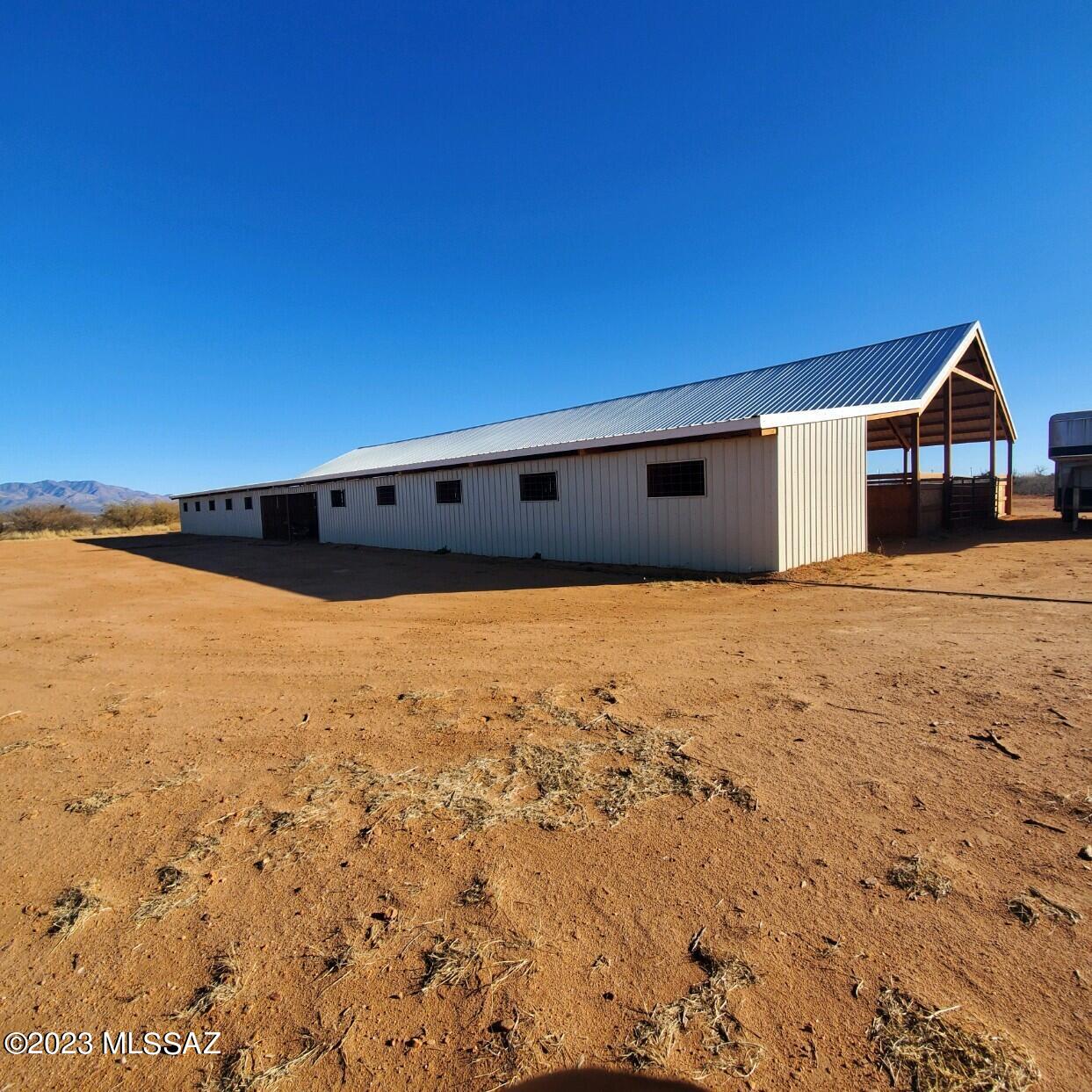 A once in a lifetime beautiful custom-built barn on 8 acres! A one of a kind in Cochise County, with a stunning covered arena. 64x144 barn 8 12x12 Stalls with rolling doors and pins to lock the stalls for safety. A tack up room with cross ties, storage stall for hay and two area right in the middle for anything; storage, tacking up or finish it for a nice size office/ tack room. 40x144 covered arena to do any event you would like without the sun beating down on you. The 8 acres is ready for you to put your home on it. Right on paved road and a two well share what more can you ask for. Even if you don't do horses this barn can convert easily to comminate for cars and trucks, arena is tall enough for simi trailer to park as well. So many possibilities this property has to offer. Owner Agent