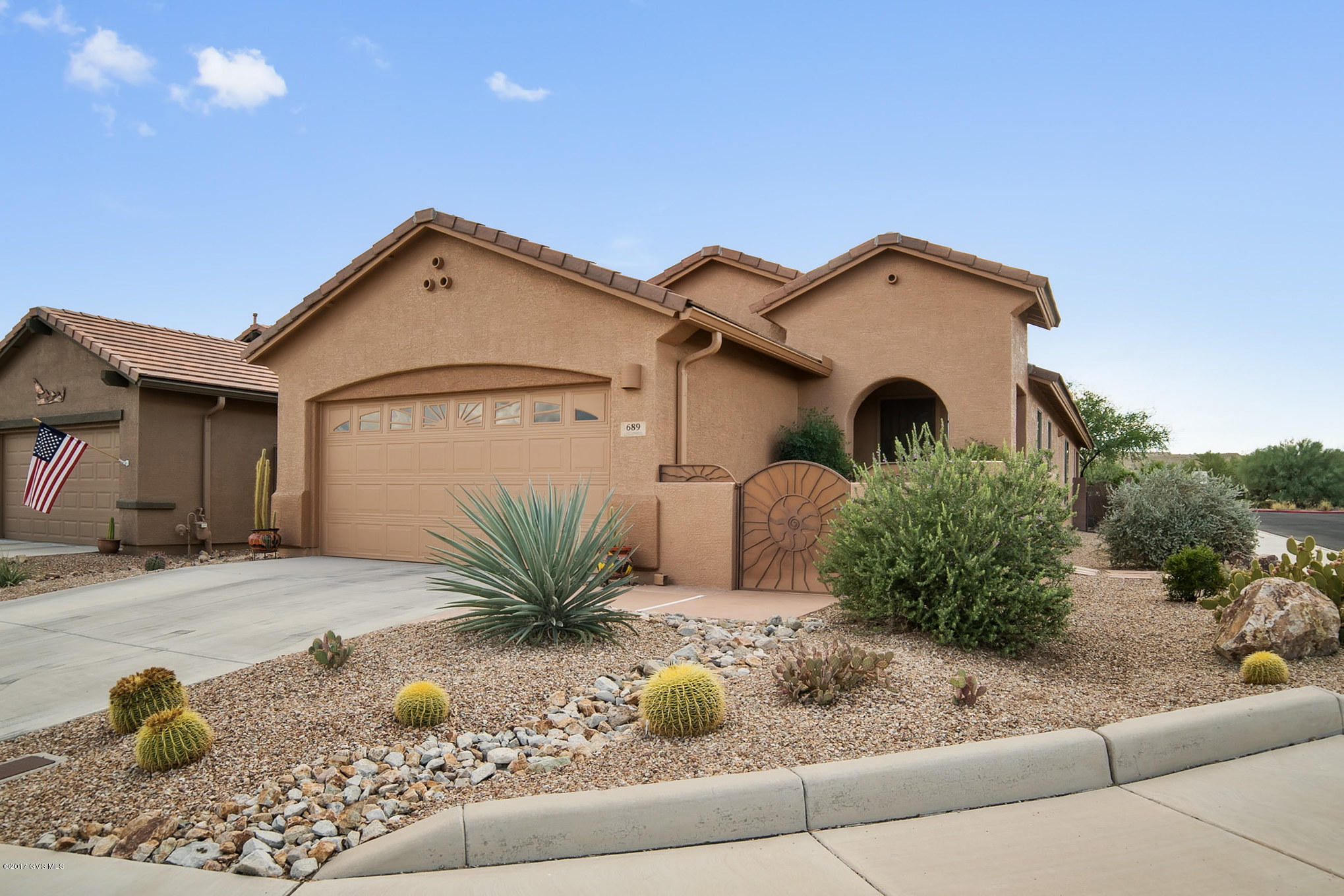 A great, private location on a corner lot, this home delivers wonderful southwest flair with lots of color. While you're approaching the archtop front entry, picture yourself enjoying breakfast in the private courtyard. Step inside and you will notice that the entire home has easy care tile floors throughout! The living room is drenched in natural light through a wall of glass providing exceptional views of natural desert. The custom tile backsplash comes to life by under cabinet lighting in this stunning kitchen and the angled serving bar will delight your guests with its upscale pendant lighting. And, the under counter dual basin stainless sink and Corian counter tops will make cleanup quick and easy. Your executive den opens to the kitchen area and has beautiful wood look plank  tile flooring. The master bedroom features an elongated bank of bay windows for added dimension and natural light while the master bath gives you convenient dual sinks and large clear glass shower enclosure. Wow - what a relaxing and fun patio. Relax under the peaceful shady ramada that extends the patio deep into the backyard allowing for endless desert landscape views - the sunsets will take your breath away!