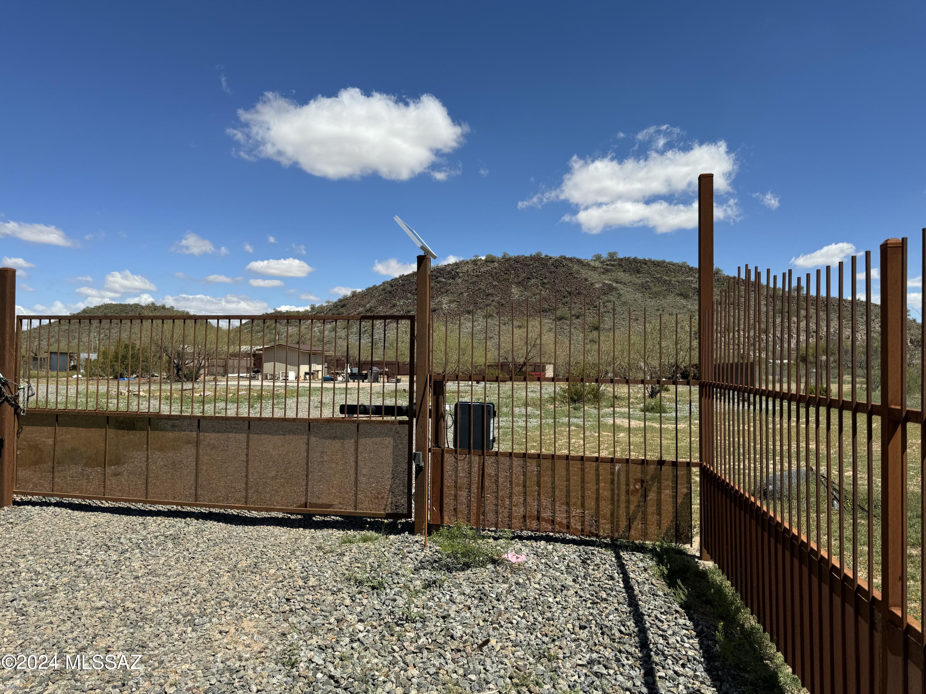 Fully fenced level usable land backing up to a pristine hill that provides serene privacy. Great location to set up an RV or mobile home per zoning. 2  water hookups and 2 electric hookups, 2 onsite septic lids installed. Shed for storage and chicken coop convey. Two concrete pads already set up for your home. Only about 30 minutes from downtown Tucson. On a dirt road. Seller may carry with 50,000 down. Terms to be negotiated.