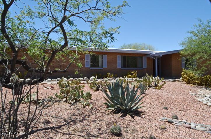 Agent-Owner's home for 23 years! Remodeled masonry beauty atop hill above wash~ Views! .9 acre estate! Open floorplan! Bright & spacious ambience! Five/six bedrooms! Two master bedroom suites! Smaller 6th bedroom could be nursery/office. Gorgeous kitchen w maple cabinetry & granite counters! Custom Alderwood doors! Remodeled bathrooms! Nice backyard patio~ perfect for barbeques & entertaining! Deep re-plastered pool! Gorgeous yards! Lots of privacy! Mature mesquites & saguaros everywhere! Beautiful enclosed backyard features vegetable & flower gardens w. flowering lemon & Palo Verde tree! There's also a 198 sq' air-conditioned mancave/workshop ! The oversized 2-car garage has storage loft! 1/2 mile walk to Sabino Canyon Recreation Area or Wes Miller Private Park & Sabino Creek! This is it!