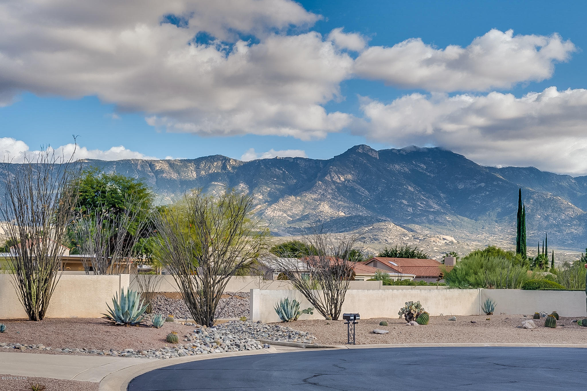 Panoramic views of the Catalina Mountains from the gated courtyard of this pristine Madera floor plan! Cul de sac location in Saddlebrooke with easy access to golf cart lanes & convenient to HOA1 clubhouse & amenities. Kitchen has granite counters,newer sink & faucet, glass & stainless hood over gas cooktop and breakfast bar. Use the nook as an office or hobby area! Cozy family room w/gas fireplace, great room has adjacent wet bar w/granite counter, perfect for entertaining. Spacious master has patio access & master bath features tiled walk-in shower, garden tub & separate vanities.  Skylight makes it light and bright! 2nd bedroom has Murphy bed w/ built in desk/cabinetry. Private back yard, paver patios, mature landscaping - see it today! Some furniture available on separate bill of sale.