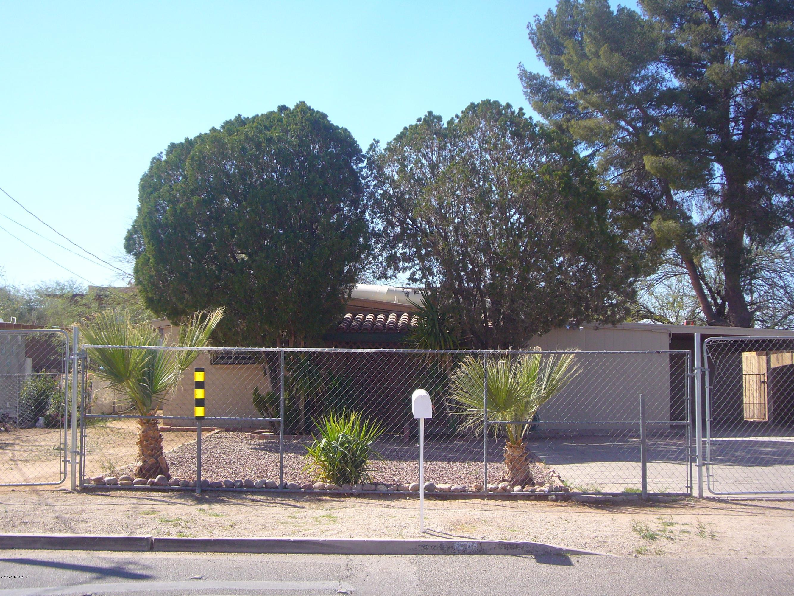 Charming home on large lot with 4 bedrooms and 2 bathrooms. Spacious living room with open beam ceiling, skylight and ceiling fan. Kitchen has flat top electric range, dishwasher, disposal, and side-by-side refrigerator with ice & water dispenser. Tile flooring throughout entire home (no carpet). Has AC. Double French glass doors lead from living room to covered patio and large back yard with 1 storage shed. Front and back yards are completely fenced. Enclosed laundry room with washer and dryer hookups off the carport. Great location close to shopping, restaurants, and all the amenities Central Tucson has to offer. 1 year minimum lease. Non-smoking home. Renters insurance required. Application fee is $45 per adult. Up to 2 pets considered with owner approval and non-refundable pet fee.