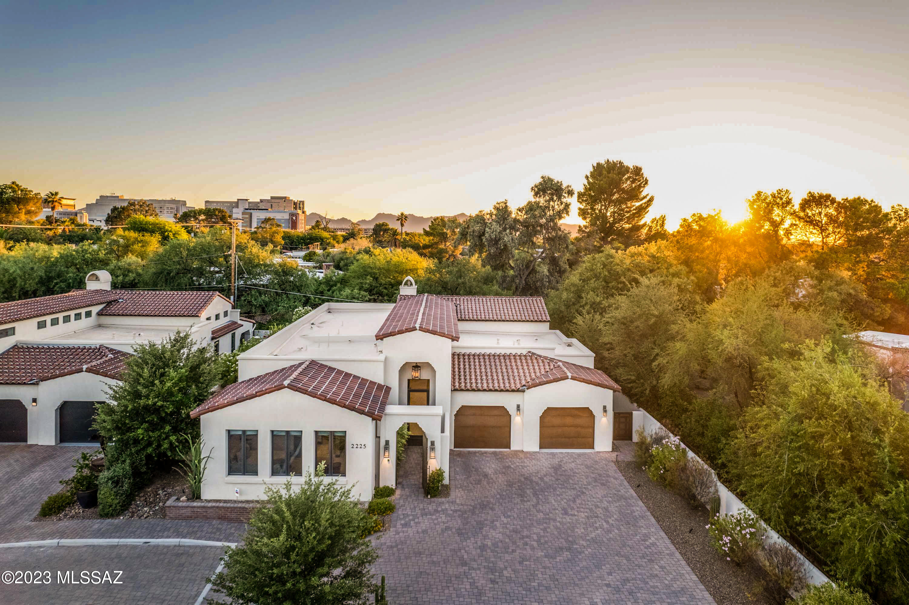 A quiet hideaway in the middle of Tucson across from the historic Arizona Inn, where just 11 Spanish Colonial style 2018-built homes are a nod to what stood before, Casa Seton is a place with a story to tell. The courtyard unveils a glass front door and entry Zagaun, a bright gallery to showcase artwork, accented by corbel arches, wood beams and clerestory glass. Flowing seamlessly into the great room and formal dining, with tall, beamed ceilings and stacked stone gas fireplace, glass doors connect to the park-like setting of birds and tall trees. An open kitchen retains GE Monogram appliances, island prep sink, pantry, soft close ebony-stained cabinetry, and bull nose granite counters. Elegant architecture purposefully evokes the past, with every modern amenity desired. The capacious primary bedroom has bonus space for exercise or seating, luxuries like surround sound, remote power blackout curtains, and access to the covered patio with a professional grade mister system. Off the primary bathroom is a spacious walk-in closet with two separate dressing sections, and the bathroom is graced with a freestanding tub, glass enclosed shower, dual vanities, and it grants access to the laundry room featuring coordinated cabinetry and a sink. 

The entry foyer leads to two guest bedrooms with a shared bathroom, while the Zagaun gallery leads to a powder room for guests.

Outstanding lot placement affords privacy under the covered patio that is pre-wired for a TV, has a gas BBQ stub, and within the serene wrap-around yard with irrigation and LED landscape lighting. Oversized two car garage with epoxy floors and custom built-in storage, plus a door to access the yard, and driveway with room to park extra vehicles, bolster form and function. 

This home instantly provides a distinct sense of place and history at the site where the Tucson Rodeo was founded and was once a finishing school for girls. Miramonte was hand-picked to build this project, a perfect home to downsize or age in place, with zero steps. Three blocks from the Modern Streetcar and minutes away from the U of A sporting events, theater, shopping, Banner Hospital, and dining, 2225 E Ambassador Court's combination of location, architecture, modern amenities, and rich history are truly unmatched. See upgrade list in MLS for more details, washer, dryer, and refrigerator will convey.
