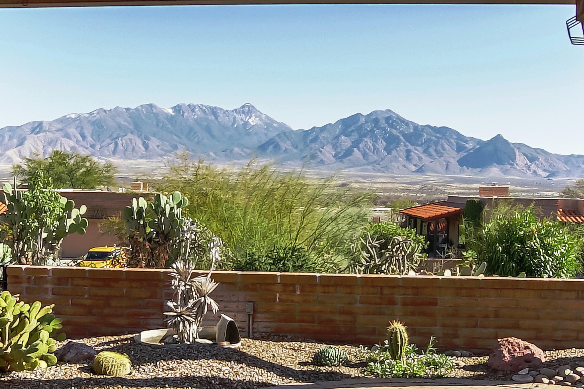 The perfect unobstructed mountain view awaits you! The red brick architecture compliments the time-honored design of this southwest home. Step through the front door and experience the Spanish flair of archtop doorways, rich Saltillo tile flooring throughout the entire home with the enchantment of plantation shutters. A corner beehive fireplace takes center stage where your guests can mingle in warm conversation. Brought to life by natural light, the kitchen’s black appliances offer a stylish contrast to the crisp white countertops and hardwood slat cabinetry. An oversized master bedroom has backyard access through sliding doors with folding shutters while the roomy master bath has double vanities, extra counter space and an easy walk-in shower. Walk out back to a full length wood covered patio with red brick pavers flowing out to desert rock with a classic Joshua tree and enjoy the magnificent mountain views offering you a tranquil setting for relaxing inspiration.