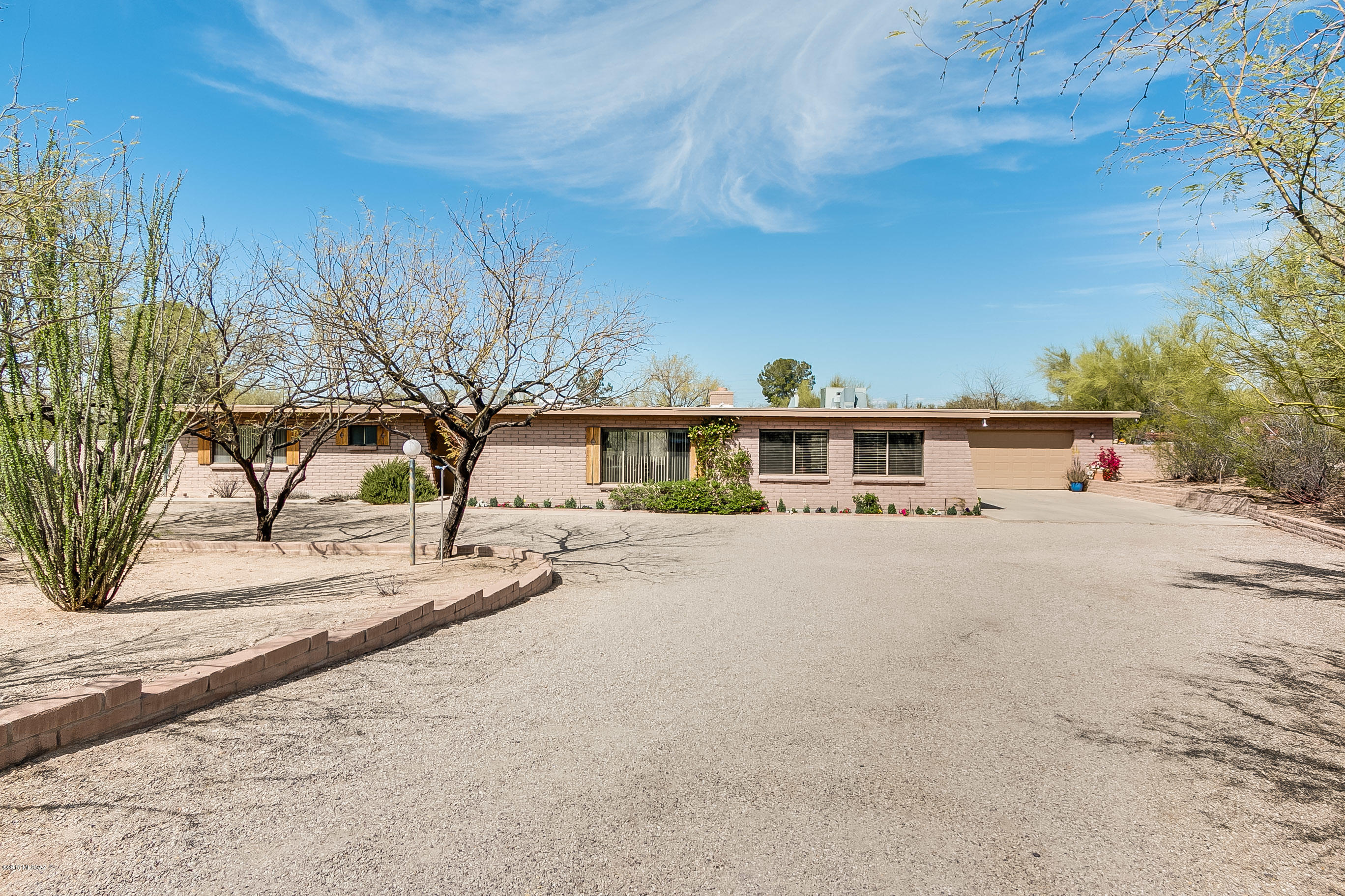 Terrific opportunity to own a slice of heaven! Top notch slump block ranch style with numerous updates including customized kitchen w/corian counter tops and stainless appliances.  Dual pane windows, zoned HVAC, spacious and professionally constructed family room with boundless storage. Recessed lighting, newer doors and hardware, tile and engineered wood flooring in living spaces.  Full length back patio overlooks private and peaceful yard. Room for RV, pool and already has a has a sport court! Over-sized 2 car garage with garage door in rear for access to back yard. Room for workshop. A mechanic's dream! Very well maintained on private .85 acre cul-de-sac lot in popular Casa Adobes West.  Do not hesitate on seeing this gem!