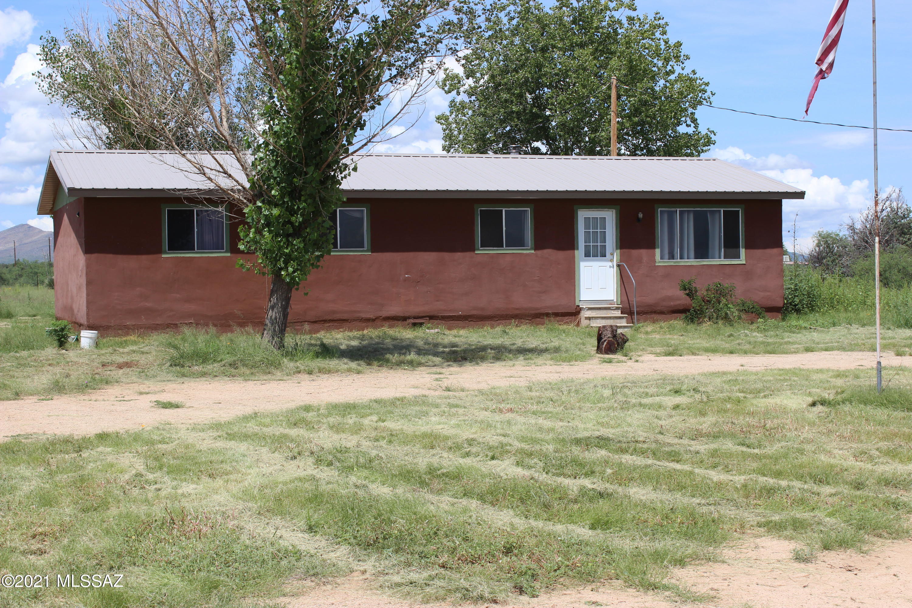 Comfortable country home (4BR / 2BA) on 2.5 ACRES with spectacular Cochise Stronghold and Dragoon Mountain views from west side deck.   Front of house faces east with wonderful views of the Chiricahua Mountains and Dos Cabezas.   PRIVATE WELL. 
 Flat ground; good soil for gardening.  NEW METAL ROOF.    Field fence perimeter of lot.  Horses are allowed.