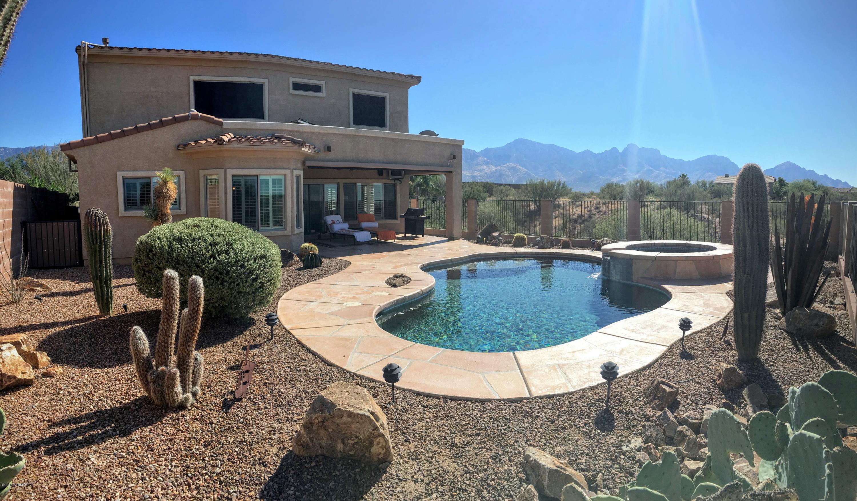 Awesome mountain and sunset views is what this contemporary 2 story home affords you. This sharp 4 bedroom 3 bath home is loaded with upgrades that you deserve. The gourmet kitchen features cherry wood cabinets w/ granite counters, pull out shelves and custom accent lighting. The upstairs master suite sports a luxury private bath w/ separate shower & tub. The guest bedrooms included ceiling fans & mirrored closet doors. The formal living & dining areas features a fireplace, tile floors & ceiling fan. The outdoors are to die for with a covered patio w/ remote controlled shades overlooking the solar heated pool and spa with sweeping views of the pristine Sonoran desert and mountains. The 3 car tandem garage includes a built-in work bench, cabinets & a cedar lined storage area.