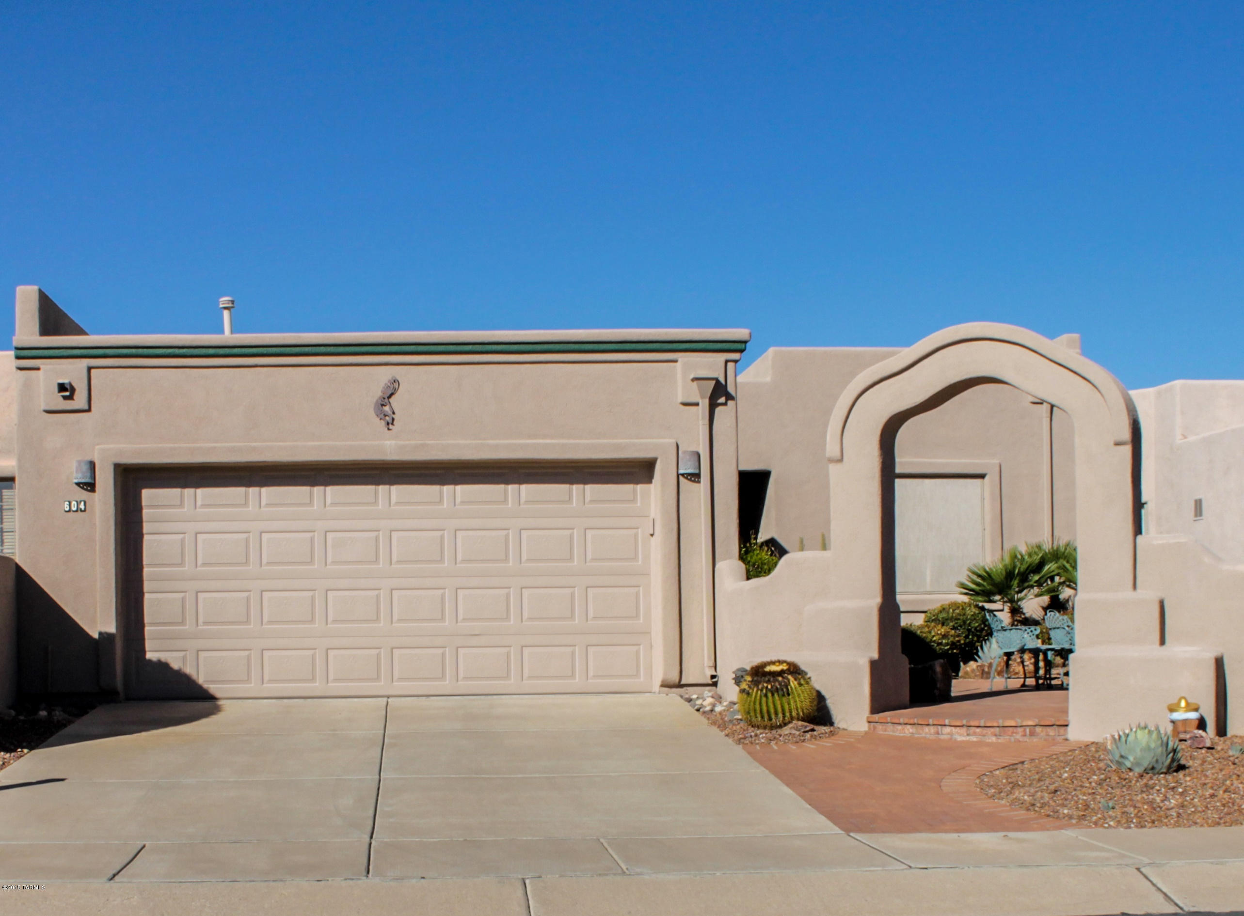 Pause for a moment to sit in the lovely front courtyard with its stepped pillar archway, scrolling brick pavers and views of mountain tops in the distance. Step into the foyer with high ceilings adding spaciousness to the great room which is highlighted by large picture windows and a Kiva corner fireplace. Soft southwest style with peeled log posts will grab your attention and lead you into an expansive kitchen with abundant cabinetry and ample counter space complete with breakfast bar. The spacious master bedroom flows into a roomy bath featuring a double door shower and large walk-in closet. The guest bedroom is complete with a murphy bed and is now used as a separate TV room. Spend time on your private covered patio with red brick pavers flowing out to decorative river rock backing to natural desert.