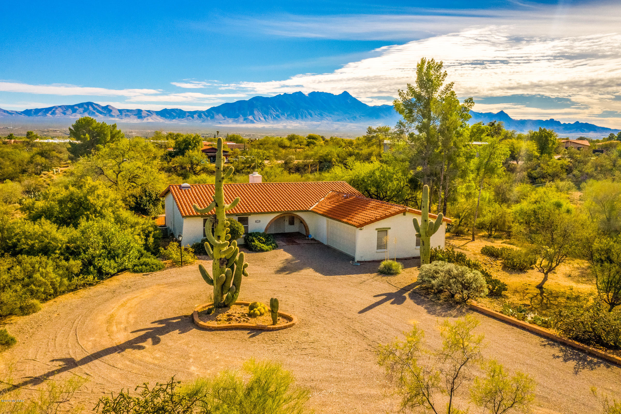This beautiful Green Valley house boasts amazing mountain views, lots of privacy and beautiful mature desert landscaping.  This home is on over an acre, has no age restrictions, and NO HOA.  Enjoy peace and quiet in the tranquil backyard with a covered porch and brick patio.  The 3 bedrooms, 2 bath home also has a bonus family room, beautiful tile, new carpet in the living rooms and a wall of windows to enjoy the views.  A screened Arizona room and lots of shade from mature trees provide a wonderful setting to enjoy the amazing scenery.   A two car garage (the garage walls are all lined with storage) and large circular driveway give you plenty of space for extra cars or an RV.