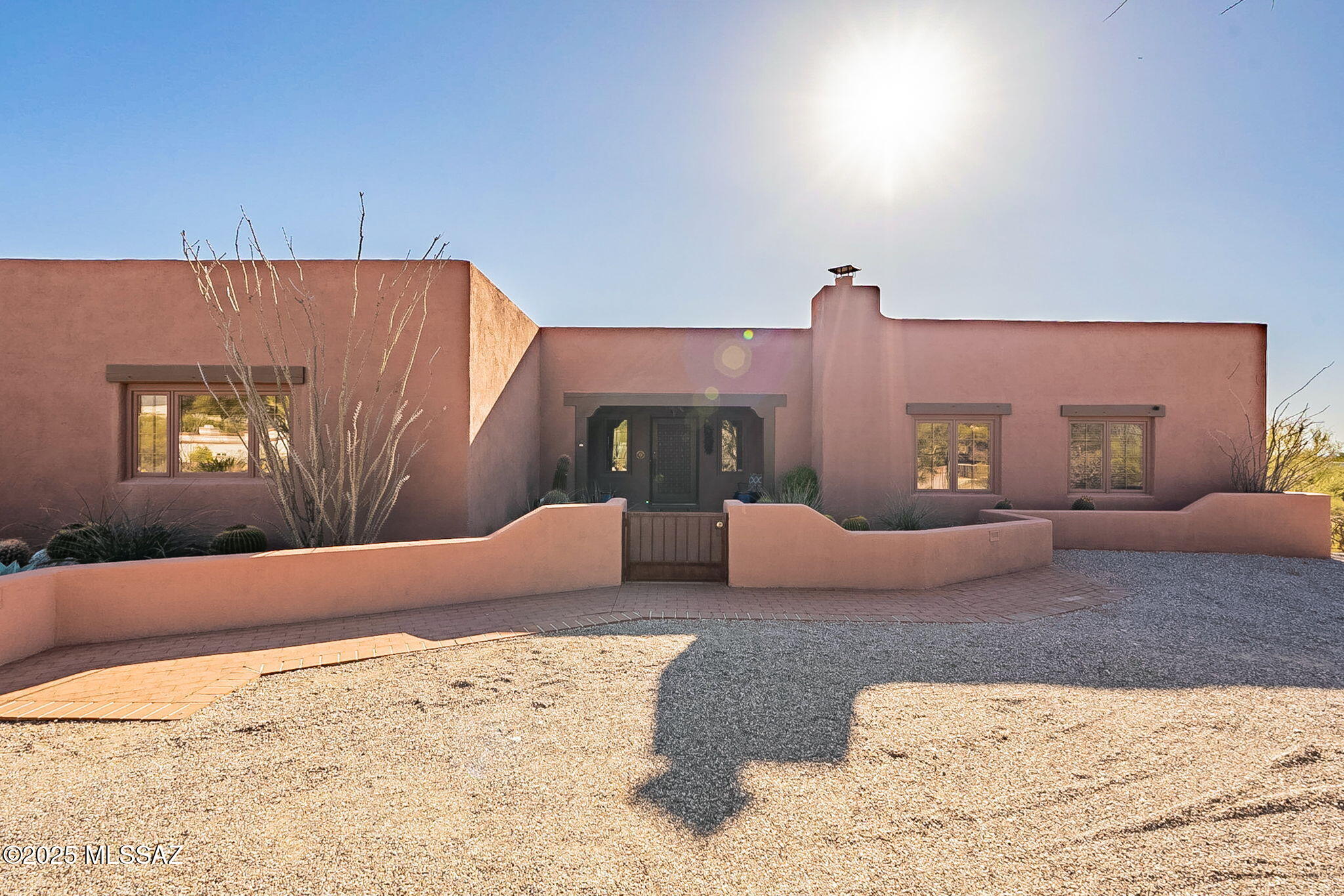 This stunning Southwestern-style home is a serene retreat perched atop a scenic hill, offering breathtaking views of the city lights and mountains. Spanning 3.11 acres of private desert landscape, the property is a perfect blend of rustic charm and modern comfort. The 2-bedroom home features a den with a fireplace ideal for intimate gatherings or quiet evenings. The spacious living room boasts exposed viga beams, with a grand fireplace adding an authentic Southwestern touch, while the French doors flood the space with natural light. The covered patio and sparkling pool are perfectly situated to capture panoramic views, making it a true centerpiece of the backyard. This home is a masterpiece of architecture and design, where every detail celebrates indoor and outdoor living.