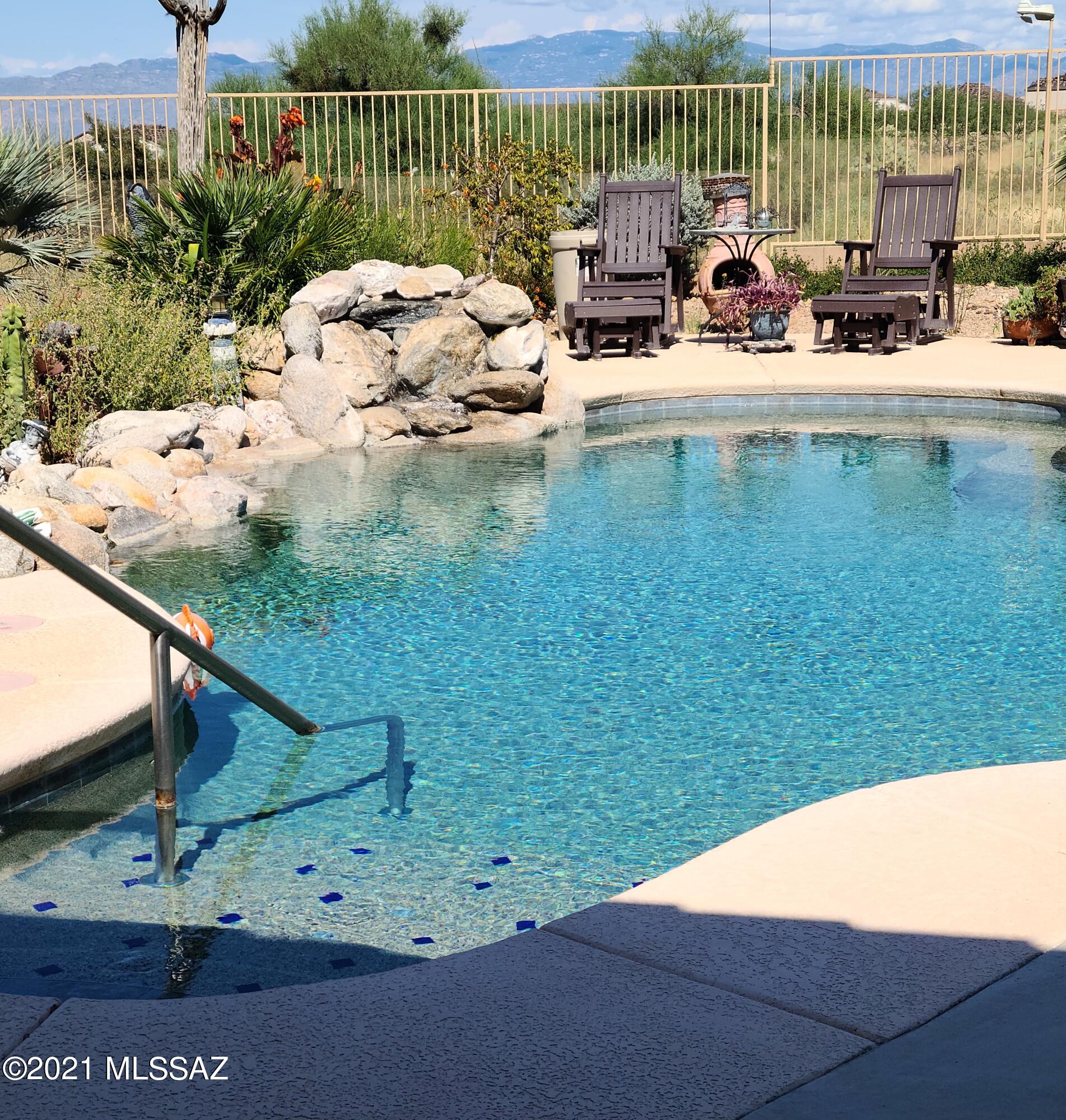 Original Owners of this beautifully well kept Lennar Whitney 51 model of the Summit Series. Tile throughout, Granite counter tops, newer appliances,  and 10-ft ceilings. Master Bath has soaking tub w/separate shower. The private backyard has stunning Mountain views, and has been transformed into a tranquil lush oasis, with easy care plants. The natural rock waterfall into the crystal clear pool adds to the relaxing atmosphere. All of this and a fully paid for Solar Energy System! This gem will not last long!  More photos coming soon!