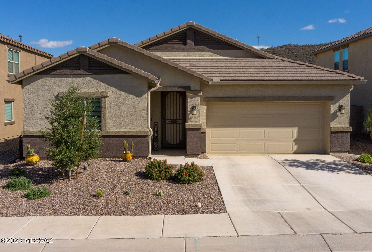 As marvelous as a model home, and move-in ready! Seller relocating out of state! Your backyard shangri-la features $30-K plus in upgrades, including a new hot tub, gas-fueled fire pit, gas tap for built-in BBQ, cool-turf, Weber Genesis 'smart' gas grill, and extensive pavers. Flexible model floorplan features 3-bedrooms, 2 1/2 baths, plus 2 dens/offices/TV rooms/future bedrooms. Kitchen sparkles with granite counters, upgraded appliances and 42'' cabinets. Living area has 11' celiings, ceiling fans throughout, and 4-panel sliding doors to the backyard. This gently lived-in home also has a utility room with sink, 'smart home' controls of the thermostat, garage and front door, a custom metal security door for safety and comfort in cooler weather,  electric outlets on 4 corners of house, and is wired for a security system.Washer-Dryer included. Garage features epoxy floors and an overhead storage rack. Saguaro Bloom residents also enjoy a community center with fitness equipment, social and meeting areas, two swimming pools, a splash pad, playground area, and 'pocket' parks in neighborhoods. Come see this finished gem of a home and everything it offers you...
