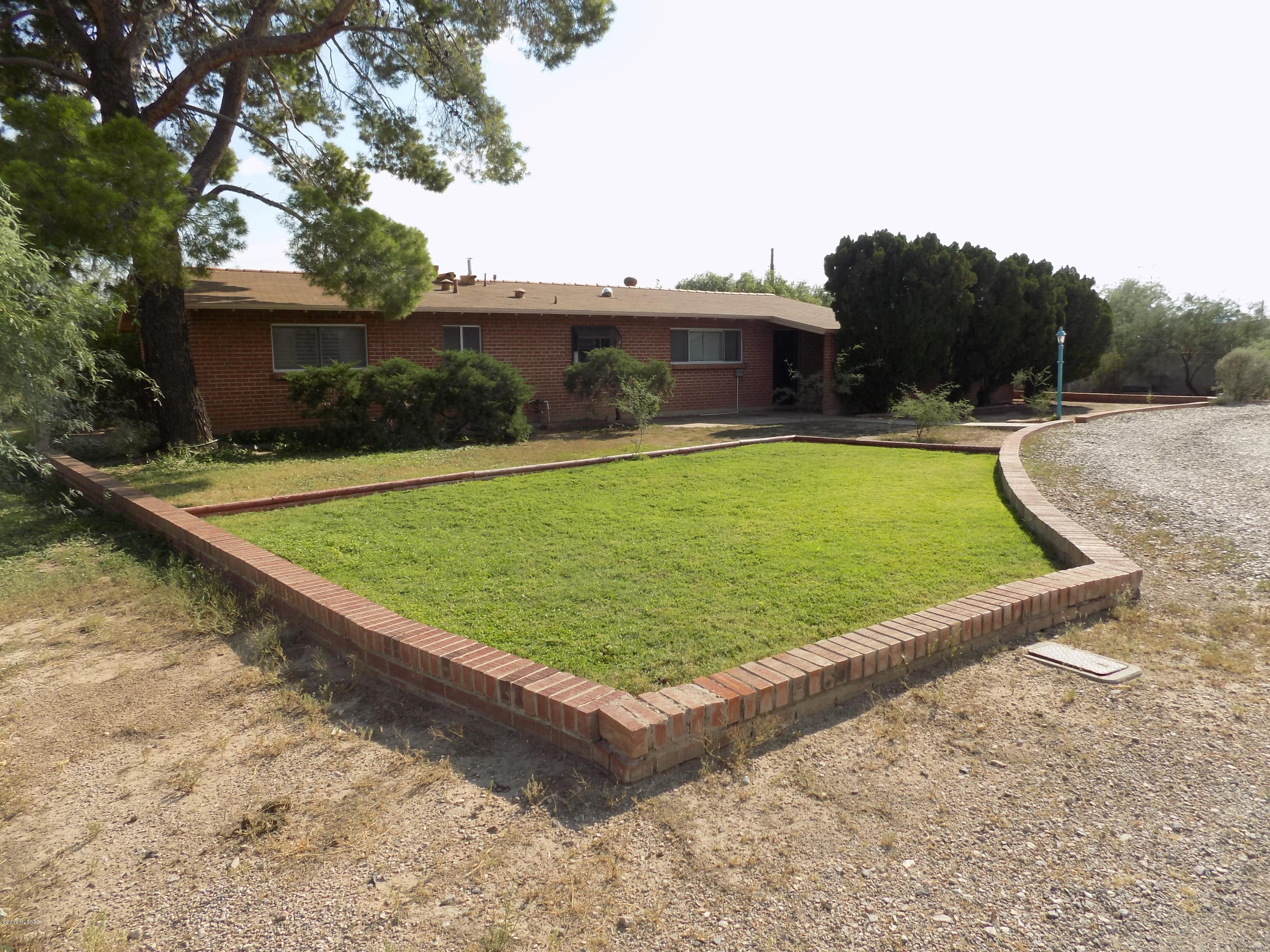This delightful four bedroom two bath original owner brick home on Tucson's desirable northwest side is snuggled in a cul-de-sac on just under a half an acre. You're going to love this move-in ready home with an open floor plan, a kitchen with an amazing amount of counter space, bountiful cabinets, and a pantry. There is newer carpet and fresh paint throughout. The bonus room could be a recreation room or another really large bedroom with it's own outside entrance and romantic fireplace. There are ceiling fans in the bonus room, kitchen and master bedroom. You'll find ceramic tile in the kitchen, bathrooms and the bonus room and lots of storage. Outside you'll find mature vegetation as it abuts a woodsy wash with bountiful life  and a covered patio that's great for entertaining.