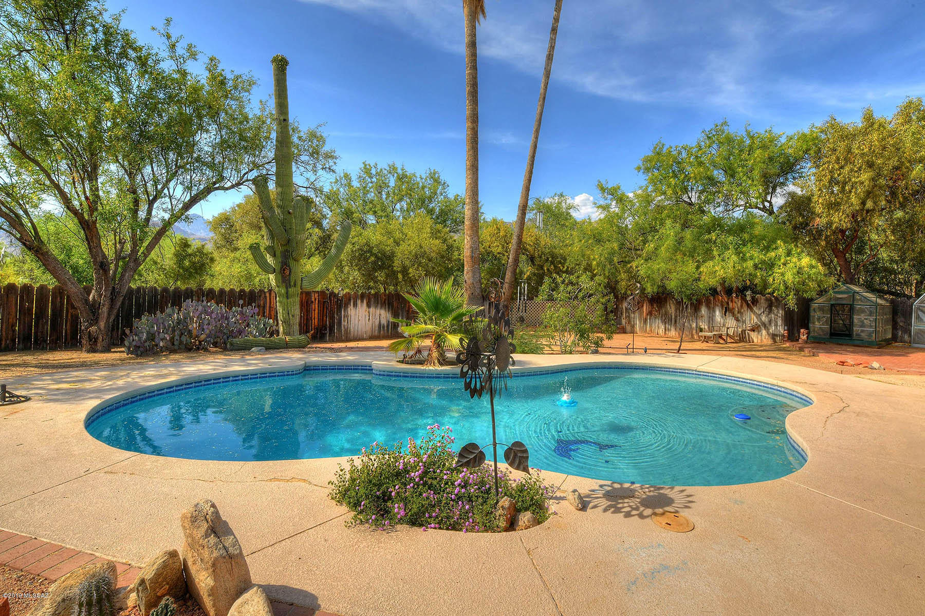 Lovely updated 4 bedroom home on 1.1 Acres in Tanque Verde Valley. Located on a corner lot with Mountain views this home has a charming private backyard w/pool. Master Suite boasts two separate vanities, jacuzzi tub, separate shower and two large walk-in closets. Tile & engineered wood flooring throughout home along with skylights and solar tubes. Kitchen has granite countertops and stainless steel appliances. 2 car garage has 110V 20 amp line and build in storage. Recently painted interior and exterior. Side yard has a shed and access for a trailer. 2 green houses are included.