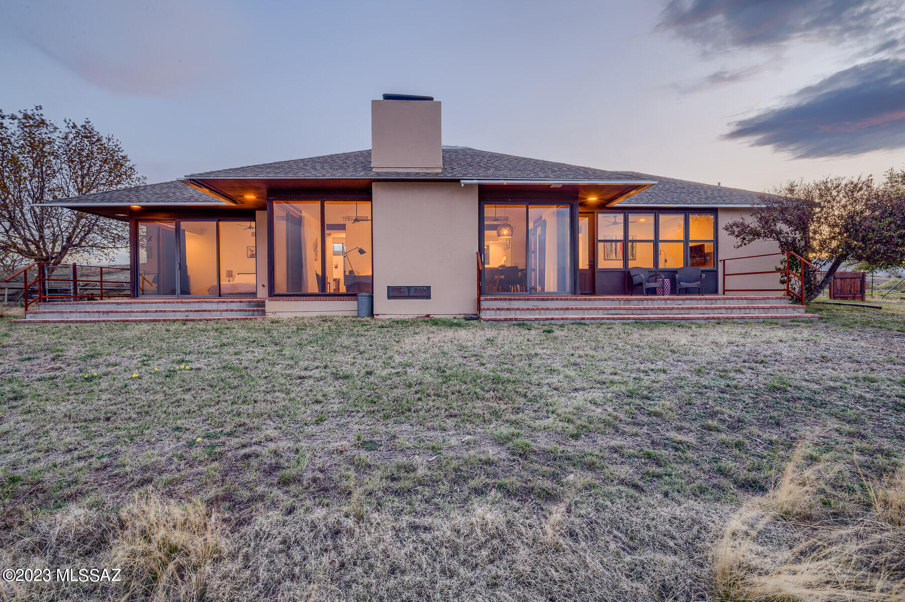 INCREDIBLE VIEWS!! Built by modernist architect William H. Cook. With inherent balance, form, and light, the house sits on 5.6 acres perched atop a hill overlooking the high grasslands of the Santa Rita foothills. Brick floors anchor the 15-foot ceilings, and walls of windows bring the beauty of the outdoors in. Two bedrooms on opposite ends of the house afford excellent privacy. Each bedroom has its own full bathroom. Large windows in almost every room - gorgeous vistas! Vaulted ceilings in the living and dining space lead to a unique pyramid skylight. Whole house and courtyard updated in 2018. 3 Stall Shedrow Barn 2 Pastures, Water Harvesting feature, fully fenced property. Owned Solar installed in 2022 with EV charger. OWNER/AGENT. Quartz countertops, SS appliances, custom kitchen shelving, bathrooms, and more. Mature apples, young apricots, and peach trees are in the front garden. The courtyard is a peaceful oasis. Spend hours watching the light play on the hills. 3 Stall Shedrow Barn 2 Pastures, Water Harvesting feature, fully fenced property. Owned Solar installed and panel upgraded in 2022, new EV charging outlet in carport.