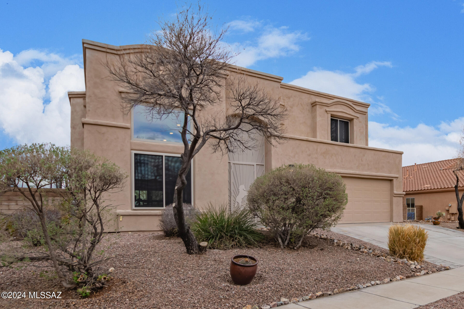 STUNNING MOUNTAIN VIEWS! Introducing this energy-efficient home with TEP Owned Solar in Rancho Del Lago! Experience Modern Elegance in this 5 bedroom, 3 bath, & 2-car garage home. Step inside to an inviting interior featuring tile flooring, designer light fixtures, upgraded ceiling fans, recessed lighting, soaring ceilings, and picture windows that let in so much natural light! The expansive great room is designed for entertaining! The beautiful open kitchen comes with rich wood cabinetry adorned w/crown moulding, SS appliances, gas range, granite counters, a breakfast bar, and a separate prep island that adds to the counter space. The spa like main retreat comes complete w/a private balcony, a massive ensuite w/a make-up desk, a soaking tub, separate shower & a walk-in closet. Ample sized extra bedrooms and 2 more full bathrooms. The backyard is an entertainer's dream, it includes a covered patio, pavers, artfully installed artificial turf and a circular fire pit with plenty of seating. Outback you'll enjoy the amazing views and the quiet buffer space between you and the golf course. Potted plants are on a drip system and will convey with the sale. New Refrigerator 5/2024! Buyer will need to assume TEP Residential Solar Program Agreement. What more could you ask for, it's like living at your own private resort!