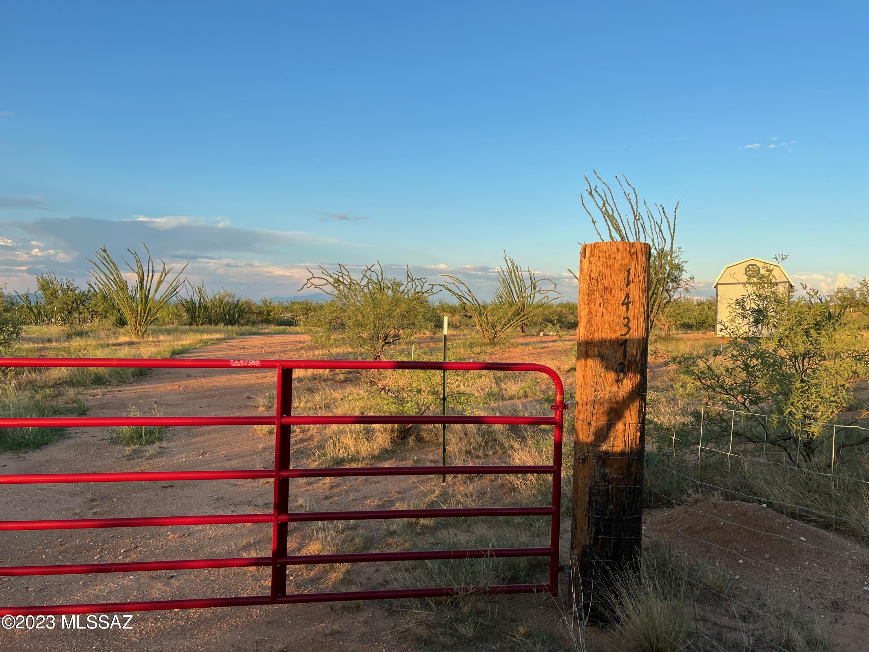 Gorgeous sunsets to be enjoyed by all in the Sonoran Desert. Ocotillo dot the landscape and create privacy with strands of natural beauty rising into the view of the Mountains. Property is staked with PVC poles to mark the lot. The buildable portion of the property is fenced with a walking gate to the wash in back where you will find wild desert animals to view in their daily lives. Property has been cleared to start the building! There is a Large Shed on site which you may be able to permit as a tiny house with the county or just use it for storage while you prep the land for your single family Ranch home! Gate in front creates a sense of security from random passersby or animals. You will need to add a septic tank and a well, OR join the masses in this area that have water delivered. Add solar power with Battery back up and have a beautiful livable Ranch with NO HOA and endless views. Dirt road is only 5 lots from the pavement. Hopefully one day there will be utilities brought out here but for now this is a pipe dream. This is the way to live out here. Call for details on building and county requirements. The seller has done so much but had to move away. Continue his dream of developing this one of a kind lot.
