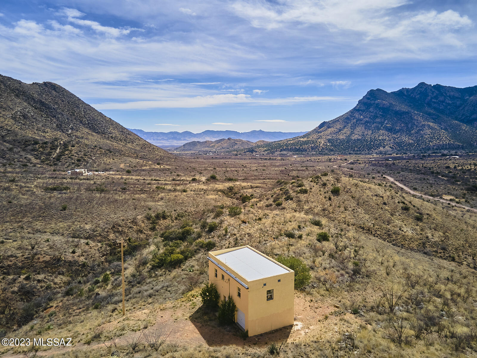 Great Bones.  Ready for your personal touch. 2 Story Home on hillside lot with breathtaking view into the entrance of Cave Creek Canyon.  Situated on Limestone Mountain between 2 hills provides privacy from neighboring parcels and unobstructed views of The Chiricahua Mountains. Primary Bedroom - 20' x 14'  / 5 ft closet, Br 2/office 9' x 7', Office 9' x 10'. No septic-incinerator toilet. Wood baseboards & framing around the doors, 18'' Ceramic Tile upstairs, Energy Star Windows. Dividable lot. Portal boasts world class birding, top 10 darkest skies for astronomers, & more!  Minutes from Portal Cafe, library, post office and outdoor recreation.