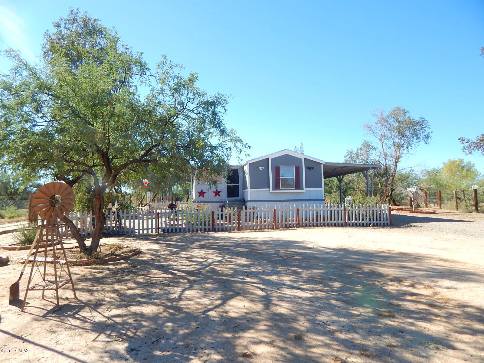 PRICE JUST REDUCED! Affordable country living at its best! Located on 0.90 acre fully fenced corner lot. With 1216 sq ft of living space this home has 3 bedrooms, 2 bathrooms, laundry room & large yard with covered patio, carport, work shop, & Arizona room with cooling great for relaxing. Kitchen with plenty of cabinet space & dining area. Master bath with walk-in closet & tub. Mature landscaping. NO HOA. Bring your horses or ATV's. 2 propane tanks convey.