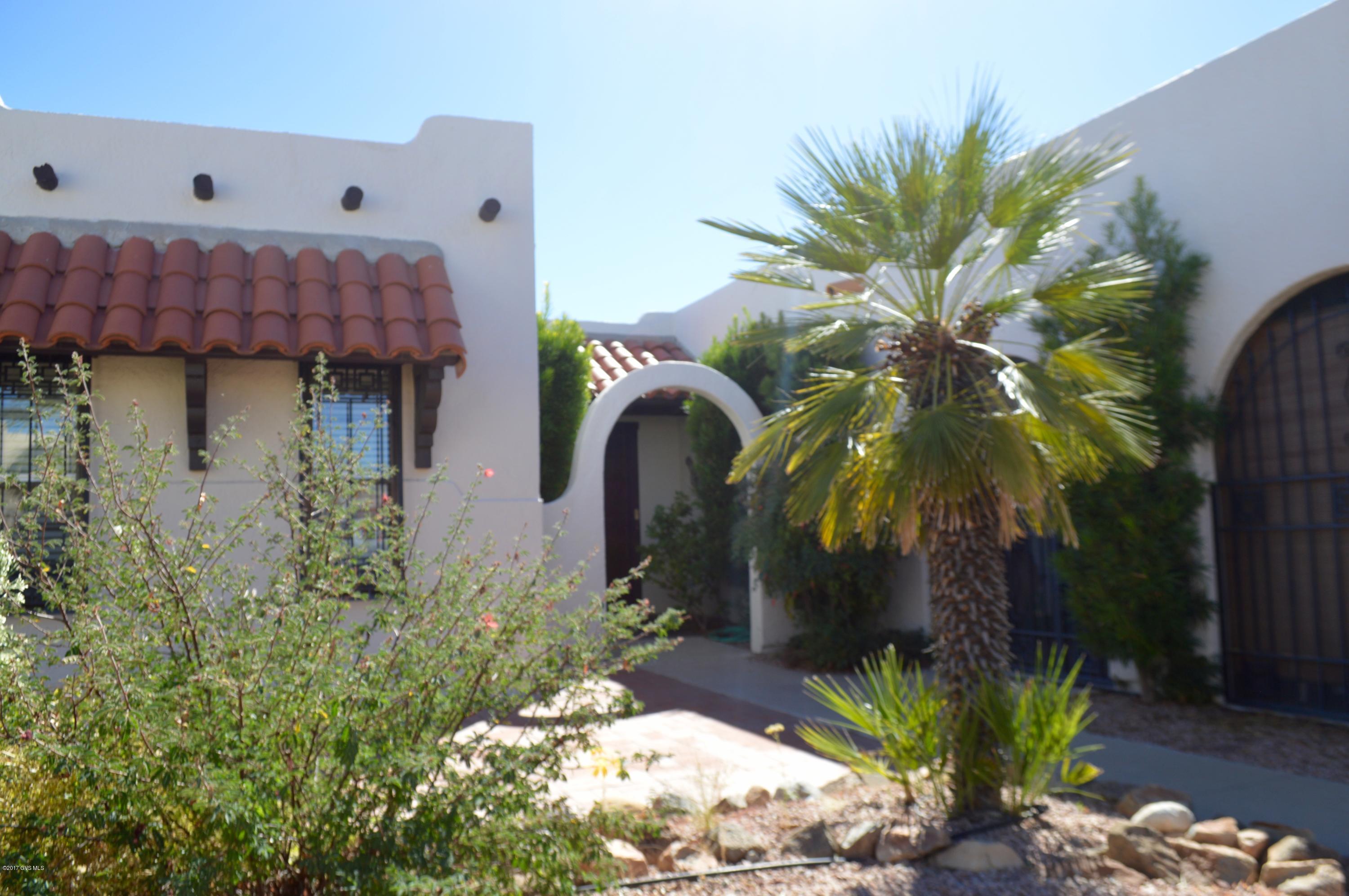 Situated in the Heart of Green Valley with mountain views, and beautiful Arizona sunrises. Common area in the backyard provides privacy & views of desert. This home offers 2 large bedrooms, 2 baths, Master bedroom has 2 large closets,en suite bath Efficient kitchen with breakfast bar, dining area, living room with bee hive fireplace, family room/den with a wet bar, large laundry room, 2 car garage with storage room and an Arizona room with a storage room. Ceramic tile and carpet floors. Close to neighborhood pool and the West Center recreation nearby. This is an end unit on a dead end street near shopping, banks, clinics and all of the outstanding recreation that Green Valley, AZ has to offer. Well maintained. Newer (2016)heating/cooling unit,& roof coat. Ready For You!