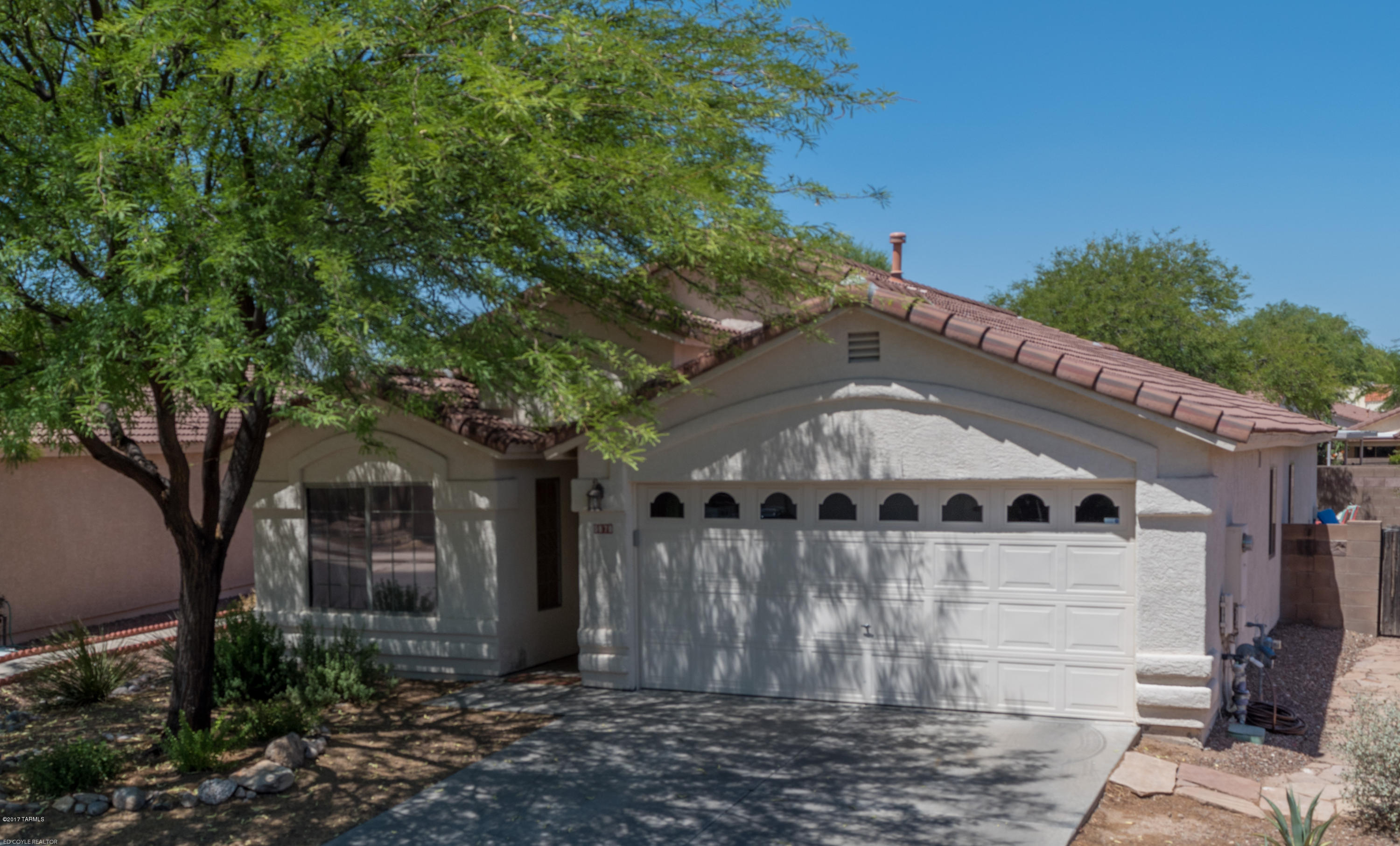 RANGE PRICED: Seller will accept or counter offers between $200,000-$215,000. Everything you need is wrapped into this charming home! Located on a quiet street and backing to a wash for extra privacy. Step inside to vaulted ceilings, updated blinds and ceramic tile throughout. No carpet to take care of! Bright kitchen has convenient island, gas oven, and newer microwave. Master bath features separate garden tub and shower, dual sinks with updated faucets, and framed mirrors. Washer and dryer in the garage will convey. Back yard has mountain views, extended covered brick patio, and just enough artificial grass to wiggle your toes--or paws--in! Affordable, comfortable, convenient… a great place to call home!