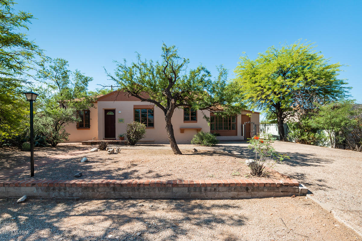 Super cute so it won't last long!  Tucson charm abounds here! Great home features living and family room spaces, REAL wood floors that have been refinished, saltillo floors and beam ceilings.  Wood burning fireplace for those chilly nights!  Large backyard with covered patio. Start your garden here! Split bedroom floor plan with 3 bedrooms, 2 baths.  One bedroom has access from the house but could easily be entered from it's own private entrance.  This room also includes a small kitchenette and would be perfect for renting out and getting some additional income!  So many possibilities here! New stainless steel appliances! Air Conditioning! Too much to list, come and get it!