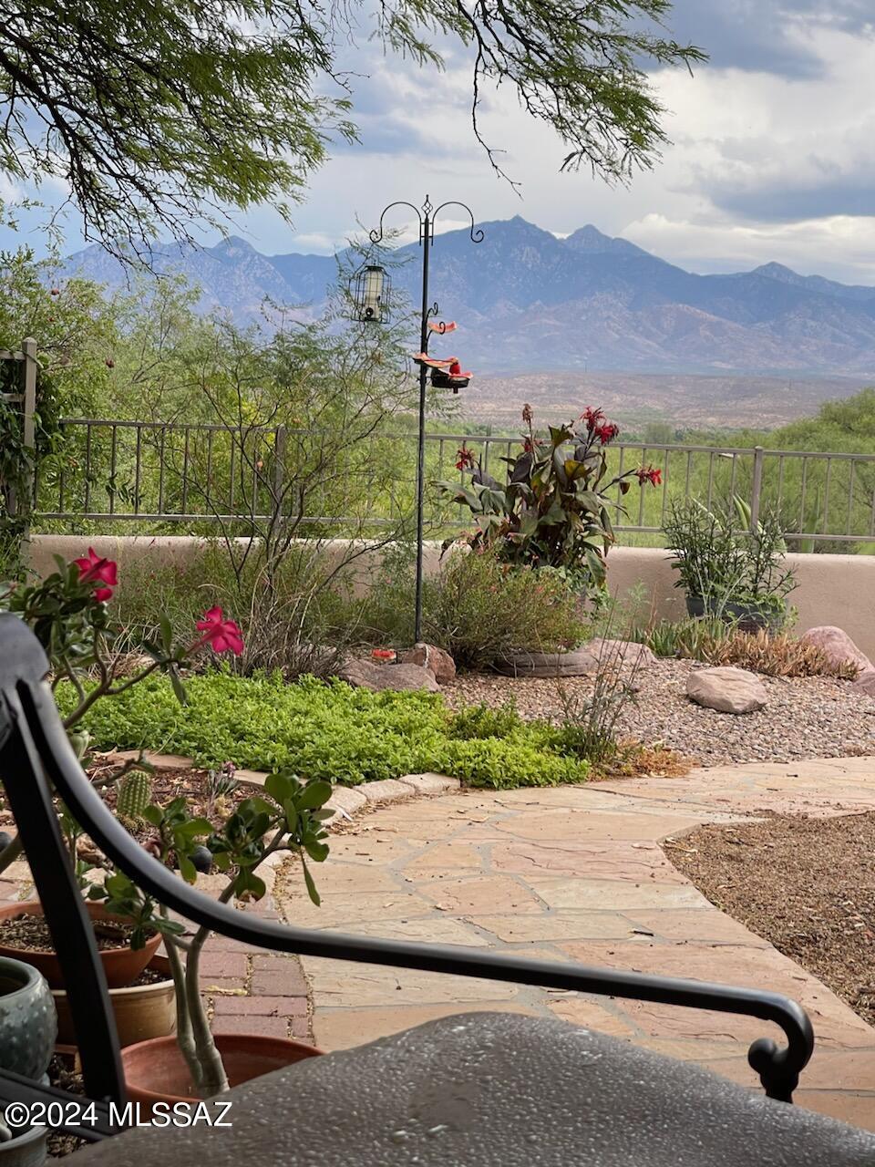 Come home to stunning mountain views at Luna Azul in charming Tubac, AZ. Flagstone floors flow seamlessly from entry through the main living areas to an expansive outdoor terrace, where plentiful seating and a full kitchen with pizza oven makes entertaining alfresco a pleasure year-round. Inside this architect-designed, newly renovated 3-bedroom, 2 1/2-bath home you'll find 10-foot ceilings, an open kitchen with a center island and upgraded appliances. Wood-burning fireplaces enhance both living and dining rooms. A generous main bedroom has large walk-in closet and ensuite bath with twin vanities, a jetted tub and separate shower. Another full bath features extensive travertine tilework and custom mesquite vanity. Eco block construction and rooftop solar ensure energy efficiency. A separate studio/workshop with mini-split is steps from the 2 car garage, which is equipped with EV charger. This once in a blue moon" opportunity includes a second lot for extra privacy. This extra lot did not pass a percolation test. The extra lot is part of the HOA, however, the house is not.