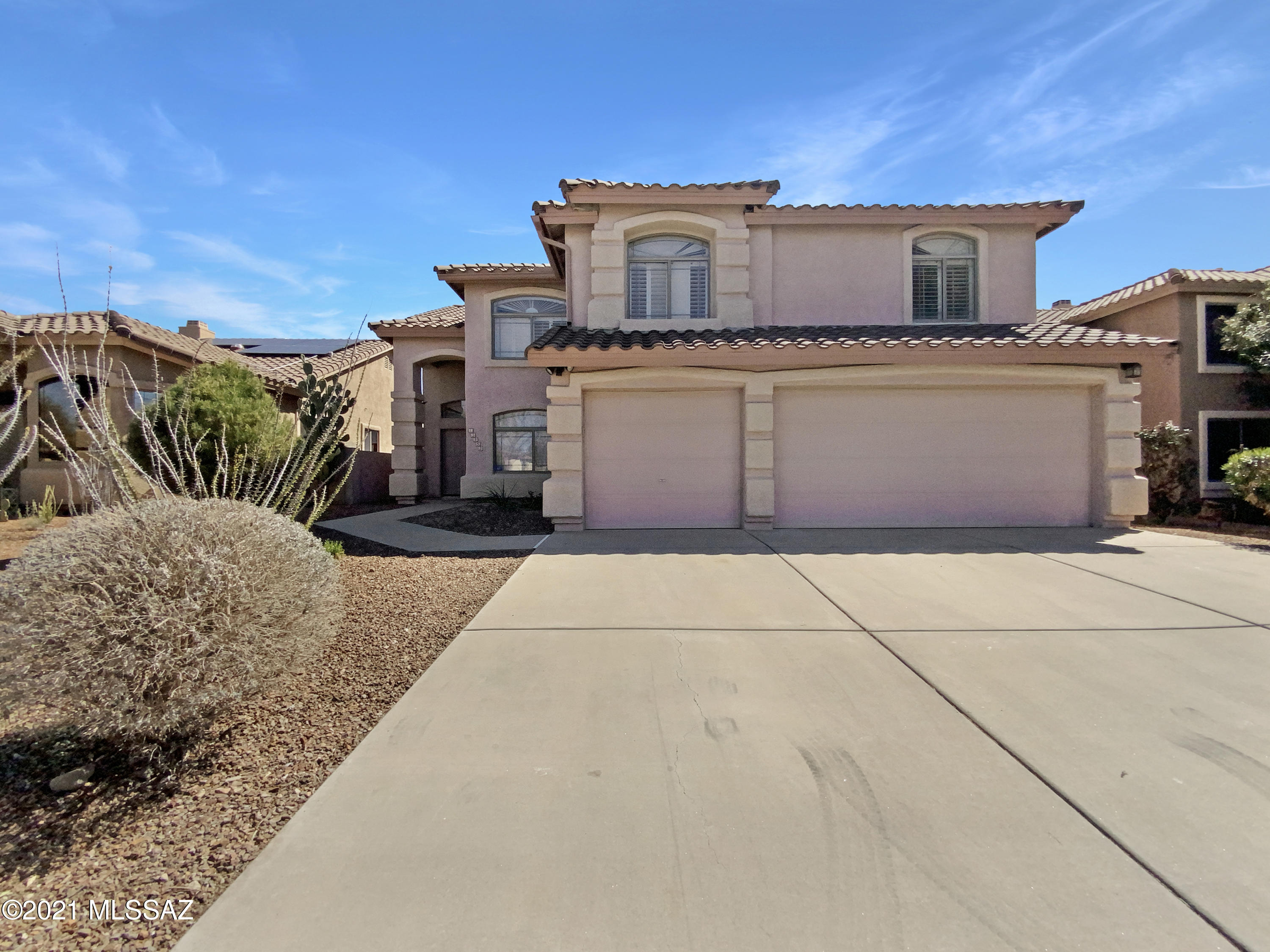 This Oro Valley two-story home offers a patio, granite countertops, stainless steel appliances, tile flooring and bath surrounds, a view deck with mountain views, an in-ground pool, and a three-car garage.