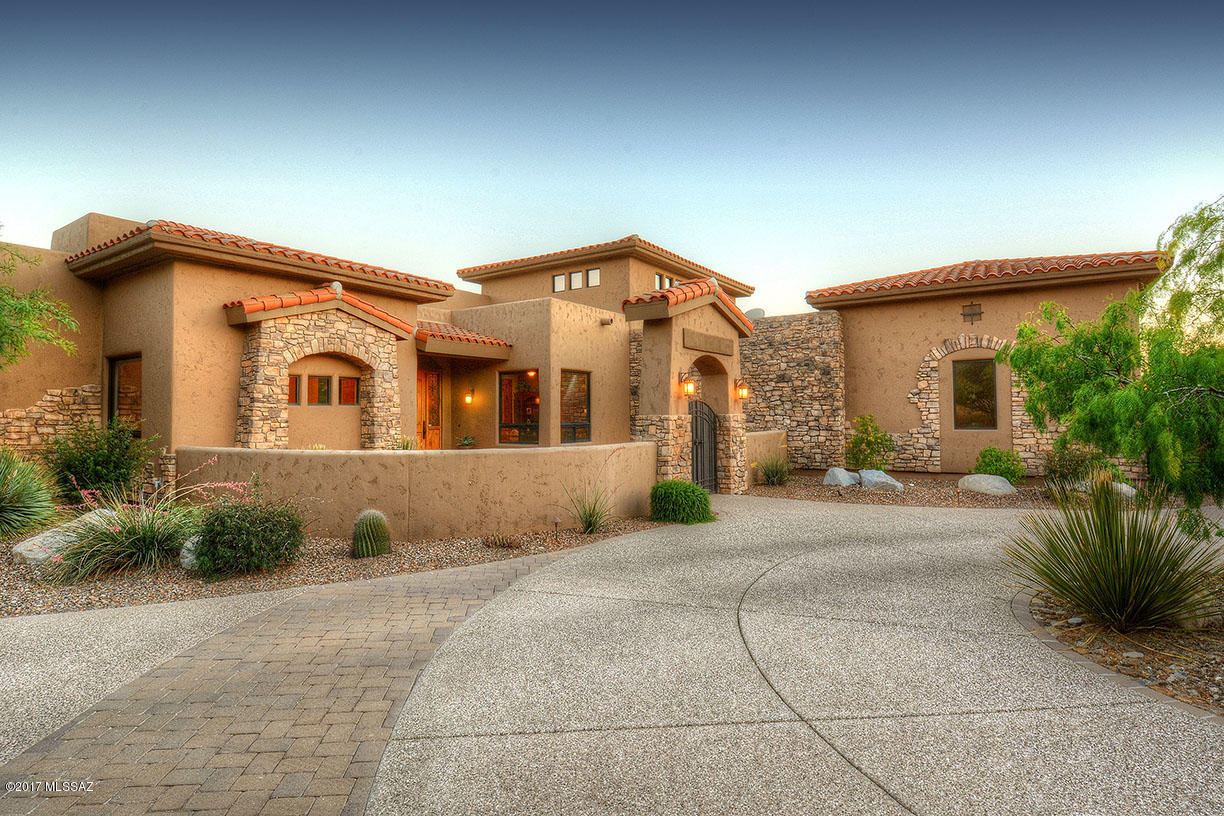 Outstanding Modern Tuscan in prestigious, gated Stone Canyon. With 4349 sqft, three bedrooms downstairs, including master bedroom and 2 3/4 baths, and 28'x20' fourth bedroom/activity room with 3/4 bath upstairs, this mountain & city view home offers circular exposed aggregate drive, courtyard entry into great room with soaring  coffered ceiling, stacked stone fireplace, 24''x24'' travertine floors and walls of windows with Catalina Mountain and Pusch Ridge views. Gourmet kitchen features alderwood cabinets, granite counters, SS appliances & breakfast bar. Gracious master suite has coffered ceiling, stacked stone fireplace, & master bath w/heated floor, spa tub, dual vanities & walk-in closet. Upstairs bedroom/activity leads to outdoor observation deck. Dramatic rear yard