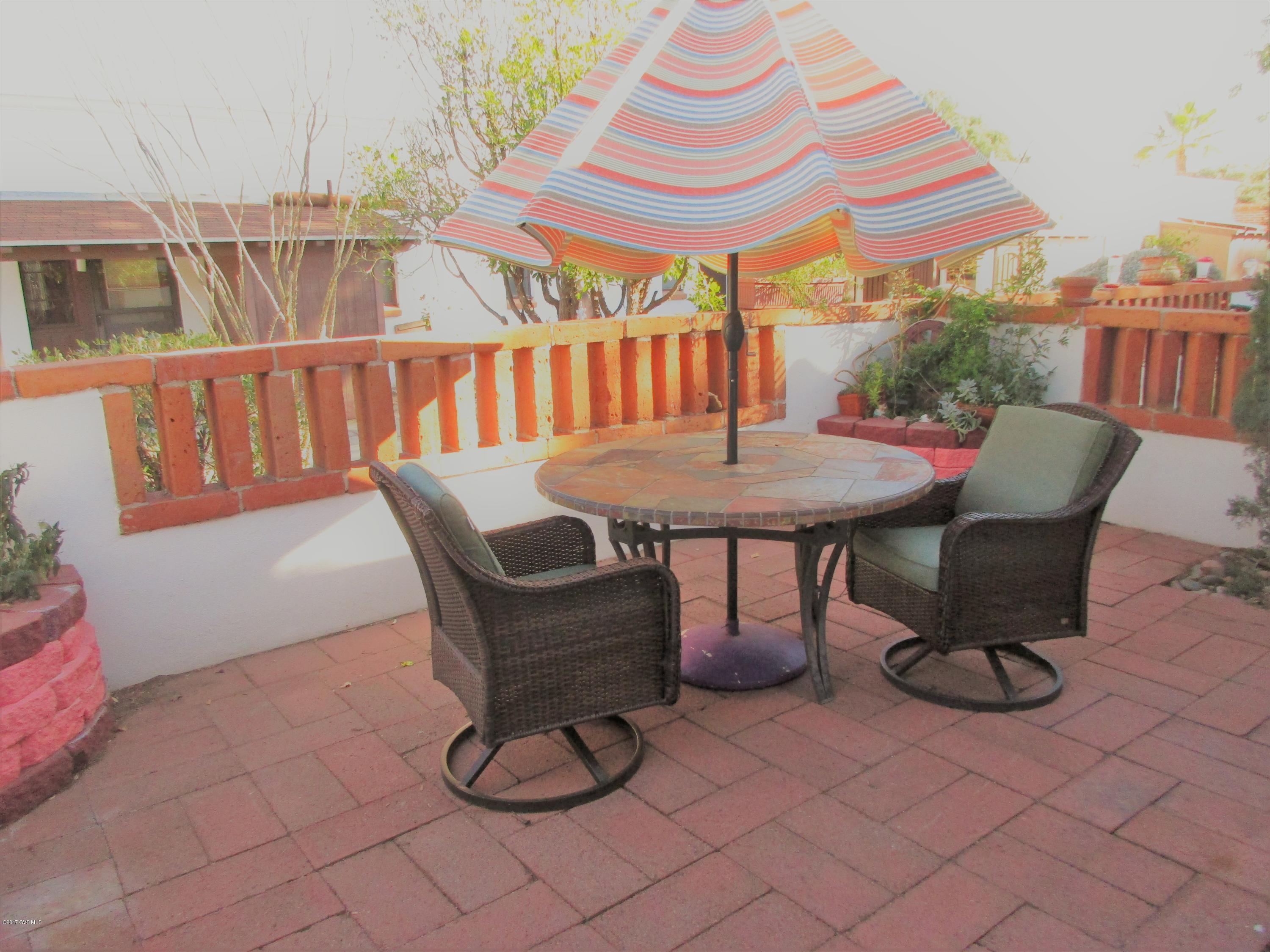 You could be living in this nice villa today! The cost makes it easy to own rather than rent in desirable Green Valley. The list of updates is impressive: ceilings free of popcorn, new windows, pretty laminate & tile flooring, new stainless appliances, new washer/newer dryer, additional cabinets & new countertops in kitchen, reverse osmosis system, updated vanity & lighting in bathroom, corner water feature & plants with drip system on patio. Loveseat, table/chairs & patio set are included at no cost. Kitchen features an area that gives you options-add an office/desk, a buffet, or storage. You choose! This villa is set back for quiet and privacy and east-facing patio brings the sunrise every morning. HOA pays for water, sewer, garbage, paint, HVAC, water heater, roof, & landscape.
