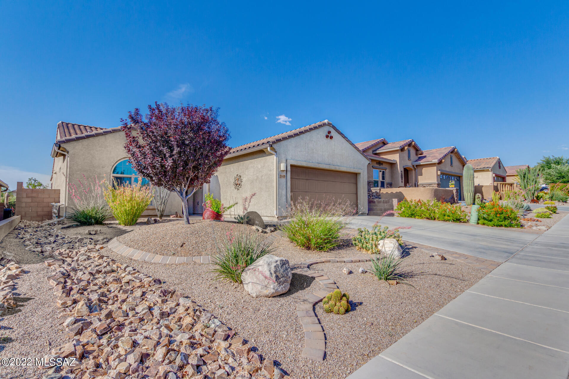 Available now! Lovely 2 bed, 2 bath residence in the Del Webb Community of Rancho del Lago! Great curb appeal w/manicured desert landscape, & a 3 car opoxied garage! Enter to discover an open floor plan w/tall ceilings, recessed lighting throughout, plantation shutters, & tile flooring. Immaculate kitchen showcases wood cabinets w/crown moulding, a walk-in pantry, SS appliances, quartz counters, & an island w/a breakfast bar. The large main bedroom features soft carpet, a pristine ensuite w/dual sinks, & a walk-in closet. Enjoy the breathtaking view of mountains under the covered patio, or from the community pool after you visit the gym and clubhouse! This home is equipped with a tankless water heater, reverse osmosis, and soft water system.  Don't let this one get away, call now!