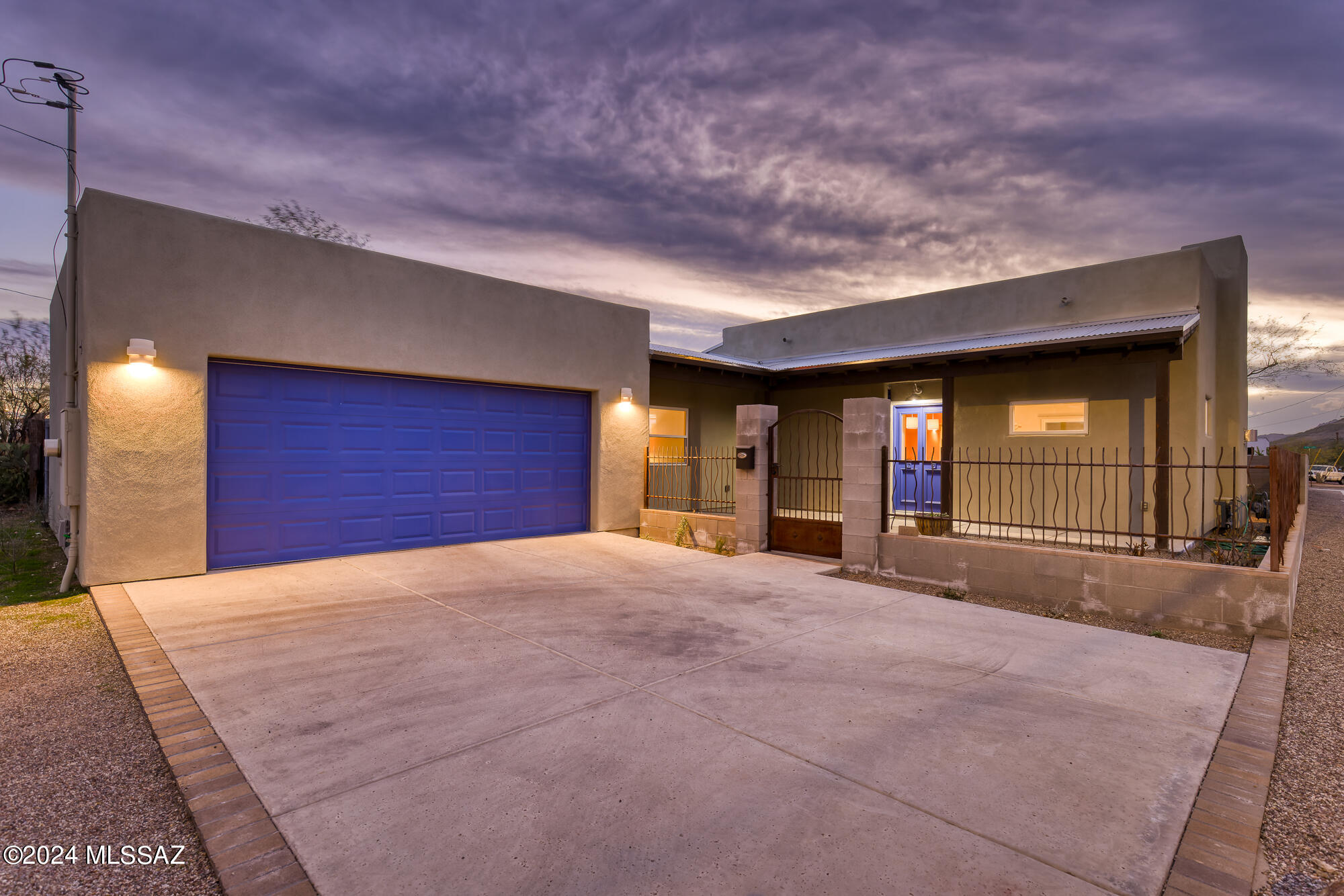 Live in a modern 2020 built home with a 2 car garage, and enjoy all that downtown has to offer!   Delightful design by owner/builder.  Enter through the custom wrought iron courtyard, taking in the ceramic tile touches and corrugated metal covered entryway.   The great room plan is open with exposed beams, wood floor and lots of natural light.  On-point cabinet colors in the kitchen blend the granite counter tops into the stainless appliances, including a wine fridge.  The back patio also is also a nod to the famous barrios in the area, incorporating corrugated metal architecture.  Colorful ceramic tiles in the just the right places.  Primary Suite has patio access, ensuite bath with dual vanities and ample walk-in shower.  Guest room has room for a bed and a cove for an office. The guest bath has a soaking tub and natural light.  Close to the famous 5-points arches, marking the original "Barrios" of Tucson.  Stop at the 5-Points cafe for coffee/lunch, and enjoy the rich history of the area. Owner/builder also built a mud adobe mid-town subdivision called Avia Ricca.