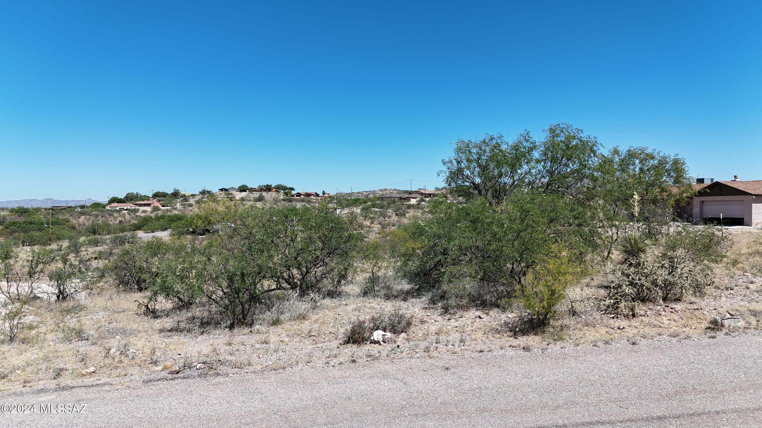 Lot between two homes.  Pretty easy to grade for the house site.  Electric at the street.  Water probably is also but buyer should verify with the water company.