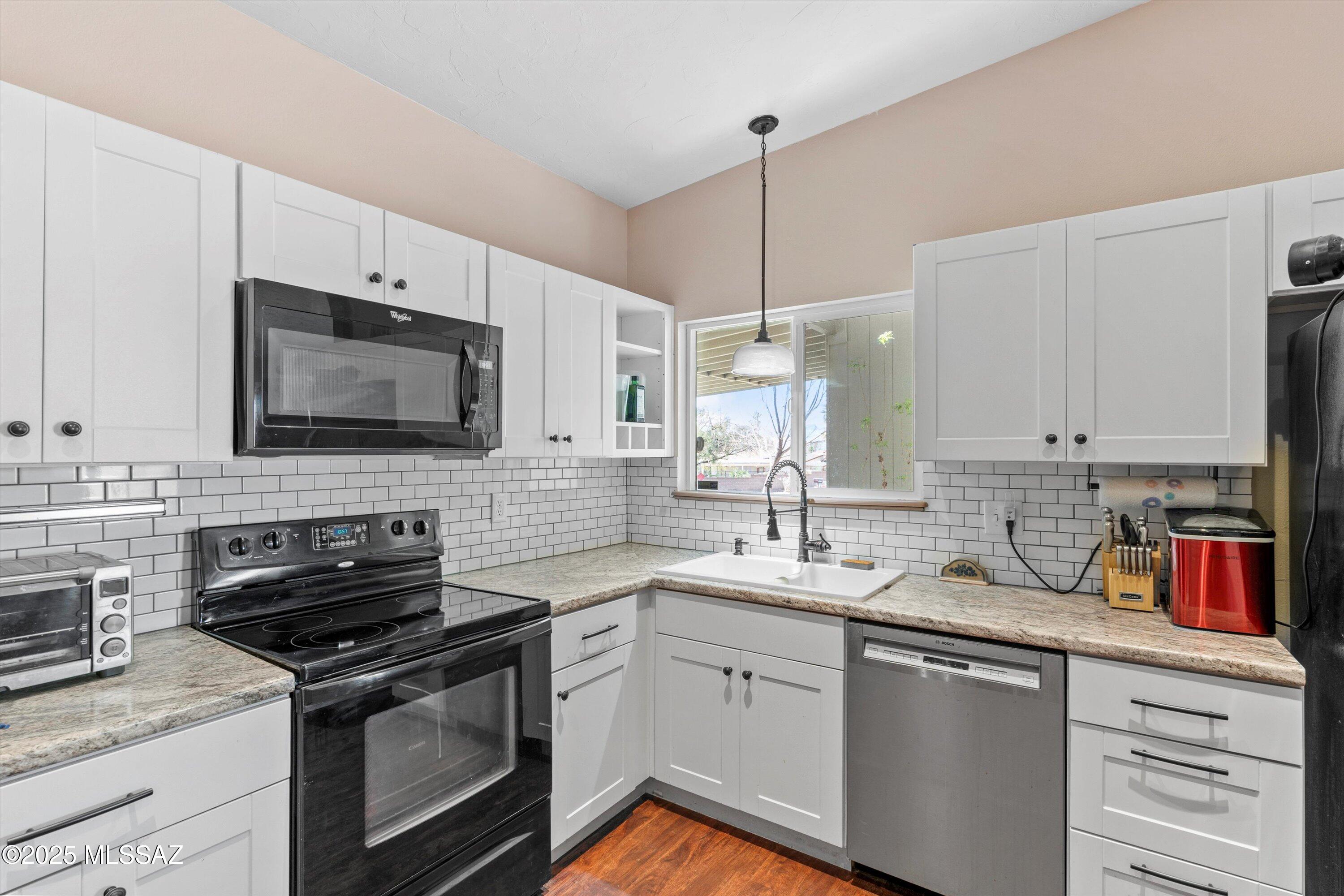This beautiful slump block home sits on one of the best lots in the community with only one neighbor and on a cul-de-sac. The home is loaded with upgrades. As you enter the foyer you will notice the shiplap accent wall, and gorgeous LVP flooring. The living room has vaulted ceilings and a new Anderson sliding door. The kitchen offers attractive white cabinets, tile backsplash, black appliances, can lights, and a newer Bosch dishwasher. Off the kitchen is the laundry room with washer and dryer. Down the hall are two secondary bedrooms with vaulted ceilings, an updated hall bath with new tub/shower with tile surround, and the master bedroom with vaulted ceiling, ceiling fan, walk in closet, and en-suite bathroom. The backyard features a covered patio, pavers, a shed, and a new steel fence.