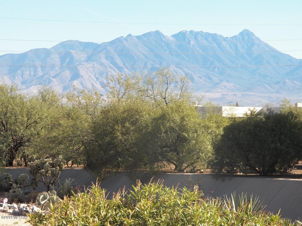 Beautifully furnished and updated Sante Fe style townhome with a superior location. Admire the spectacular mountain view from the great room, rear patio, or walking trail that meanders along the arroyo bordering this 2BR 2BA townhome. The Esperanza Estates community pool/clubhouse is only a block away. This property does not have a membership to GV Recreation at this time. The interior radiates with abundant natural light, warm desert tones on accent walls and rustic pine flooring in the great room, which blends perfectly with light beige ceramic tile in the kitchen, entry and baths. Enjoy your morning coffee in the breakfast nook facing the front courtyard through an arched garden window. The kitchen, open to the great room, sparkles with light Corian counters and white appliances. The master bath has a bit of a Mexican flair with a Talavera sink, decorative metal mirror, and splash of color.
