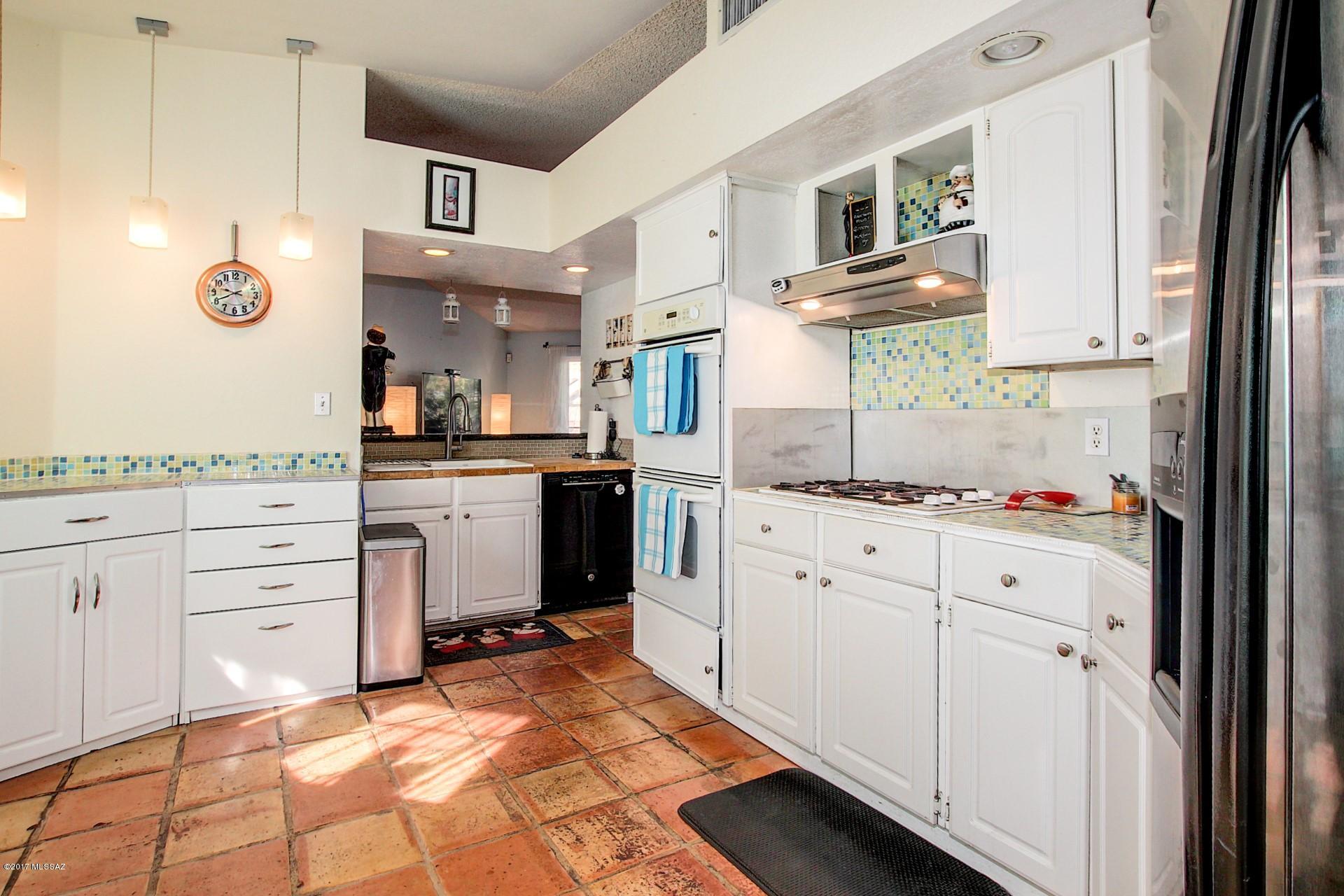 Absolutely Charming single level Home with great curb appeal and Mountain Views. Soaring ceilings, saltillo tile, neutral palette, and formal dining area with built-in serving buffet. Enjoy the unique kitchen with white wood cabinets, colorful tiled counters/backsplash, and upgraded lighting. Beautiful laminate wood floor in master retreat, plant shelf, walk-in closet, private en suite with vessel sinks, tile floor, and designer fixtures. Generous size bedrooms, ample closets, and upscale baths. Backyard covered patio, garden area, pavered patio, wood fence, misting system and fire pit. A must see Home on your list.