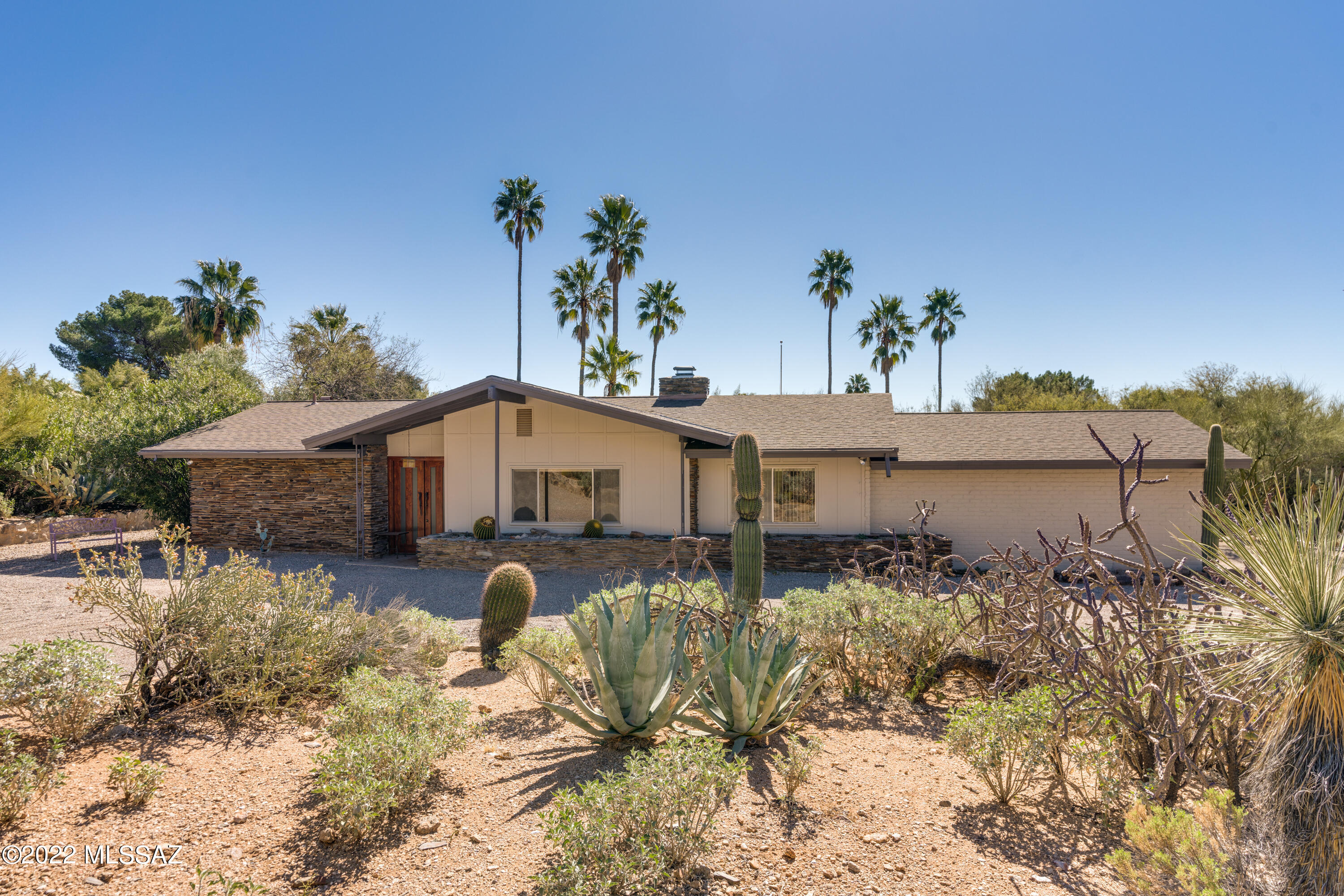 Classic mid-century adobe brick ranch home situated on 8th fairway of Skyline Country Club.  2 BR, 2 ½ BA + den/office/gym/nursery flex room outside owner's suite. Major remodel/redesign(2002) resulted in a gourmet kitchen w/Subzero/Viking appliances, stainless steel countertops, maple cabinets & fabulous walk-in wine cellar. Formal Living/Dining areas, w/a flexible floorplan & ample exterior spaces allow for entertaining on a small & cozy, or massive scale. Spacious family room off kitchen has stacked stone fireplace. French doors lead from this room, the kitchen & the owner's bedroom suite to east facing patios w/golf course views. Private guest suite allows flexible use w/double door entry, (Murphy bed) & a private guest full bath. Addtl ½ bath. Travertine floors throughout.