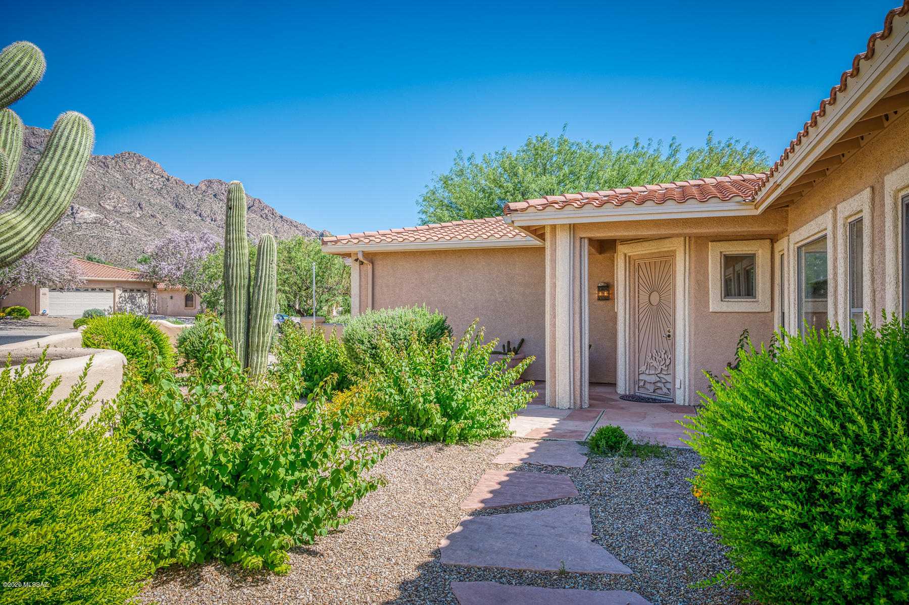 This former model home is located in the exclusive gated community of Sunstone Estates. Beautifully upgraded & just a short golf cart ride from Oro Valley Country Club you will love living here. The extra large lot boasts easy care landscaping w/ fruit trees, pathways & an in-ground spa complete w/ rock waterfall. Offering Pusch Ridge Mountain views, an oversized 2-car garage, that can also accommodate a golf cart, & the community pool just around the corner you will have everything you desire. The open kitchen has a large island, granite & cherry wood cabinets. The owner's suite offers 2 walk-in closets, a large bath including separate tub, shower & dual vanities. The carpeted AZ room is a welcoming place to relax & spend time. Oro Valley luxury living great year round or lock and leave. Seller will remove the screened in Arizona room at the buyers request and return it to a porch at the sellers expense.