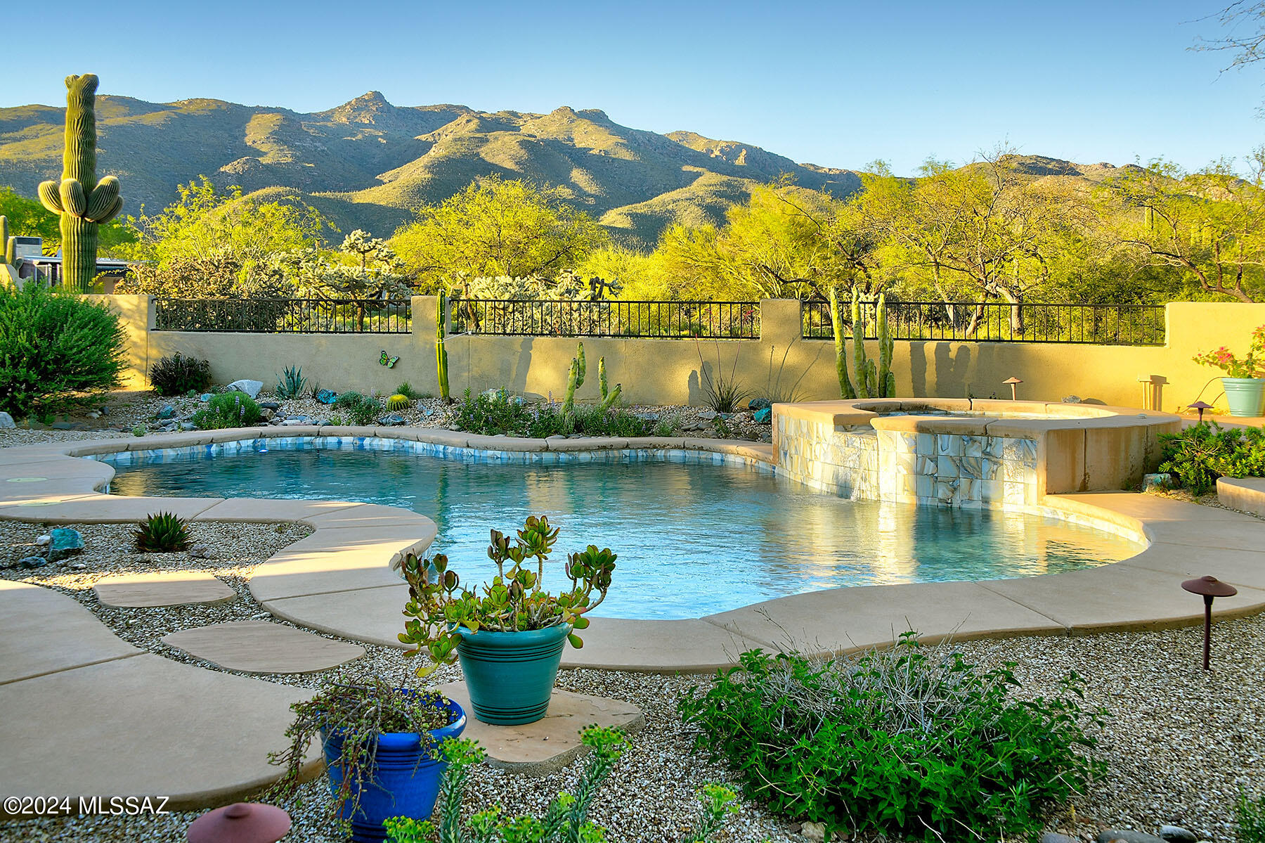 Views! Views! Views! Welcome to your desert sanctuary nestled within a serene, gated enclave in Northeast Tucson. Positioned at the cul-de-sac's end, privacy reigns while panoramic 180-degree mountain vistas serve as your daily backdrop.   As you step through the custom arched wood front doors, prepare to be captivated by the meticulous attention to detail woven into every corner of this semi-custom Sombra-built Santa Fe style home. This exceptional property boasts an oversized 3-car garage with custom-built storage cabinets, a thoughtfully designed split bedroom plan featuring 3 bedrooms plus an office/den, and 3 full baths. The heart of the home, the great room, invites with its warm embrace of a kiva fireplace and rustic wood beamed ceiling, ensuring cozy evenings year-round. Your culinary aspirations find expression in the beautifully appointed kitchen, adorned with new countertops, backsplash and refrigerator. Outside, a symphony of desert tranquility awaits, with multiple seating areas beckoning you to unwind amidst the natural splendor or observe the abundant wildlife. Whether you seek solace by the second kiva fireplace or delight in hosting gatherings around the outdoor kitchen, this property effortlessly merges indoor comfort with outdoor allure. Embrace the luxurious upgrades thoughtfully curated by the current owners, including a remodeled Primary Bathroom, new HVAC, new paint, updated light fixtures, refreshed pool surfaces and equipment and enhanced view fencing. Experience the essence of desert living redefined within this peaceful oasis, where every detail invites you to savor life's finest moments.
