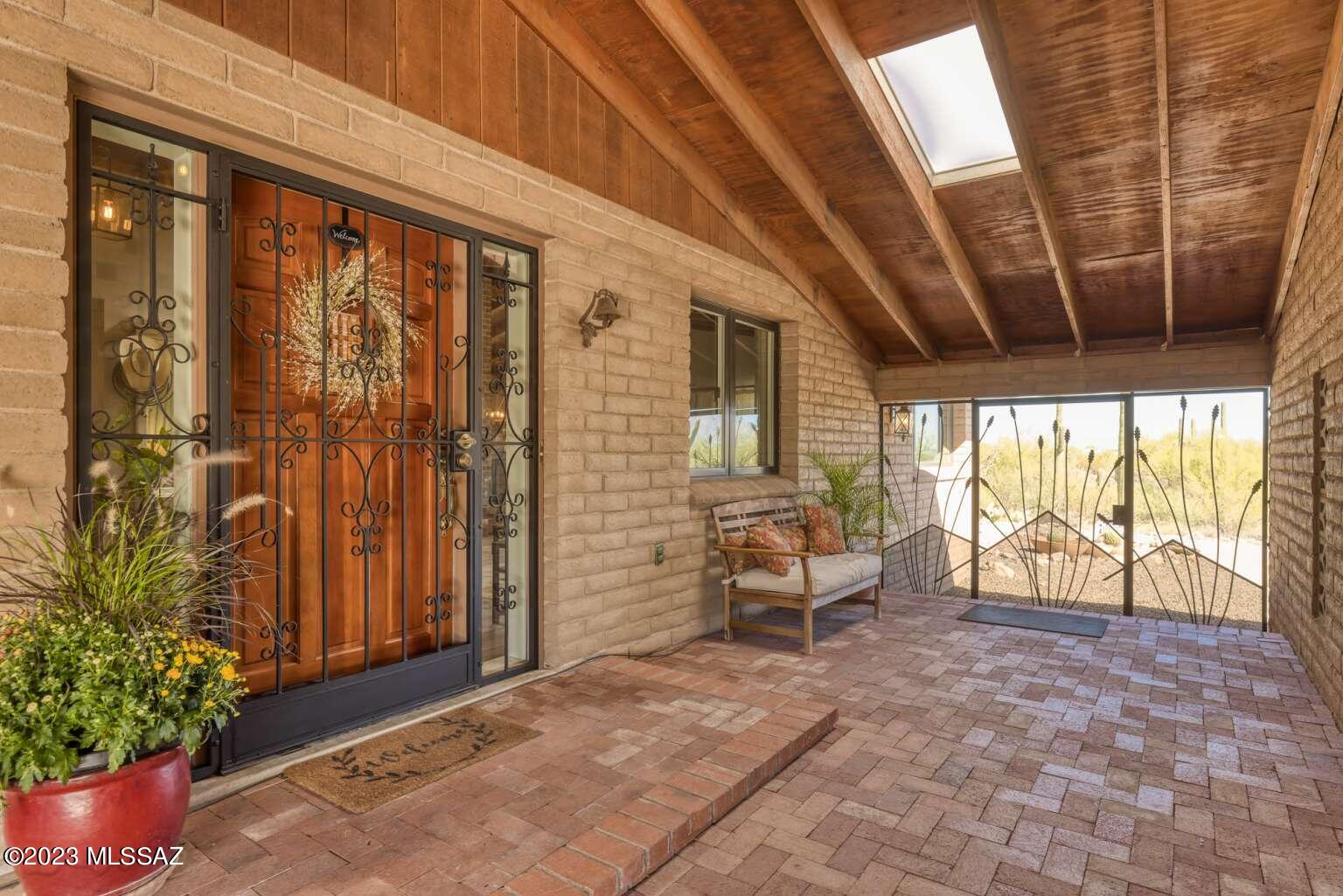 Enjoy the stunning views from this desirable Westside ranch home that sits on 2.73 acres of saguaro studded land with various fruit trees and diverse wildlife. This home features an extra multipurpose room in the master suite, a spacious fully renovated kitchen, vaulted exposed beams, and a large enclosed yard with many areas to entertain.
Imagine inviting guests through the custom ocotillo gate to the covered brick paver patio and preparing them meals on the vast quartz countertops and gas stove. Dine while enjoying the stunning scenery from the many seating areas inside and out. Picture cleaning up at the gorgeous hammered copper apron sink (1 of 2 kitchen sinks!) as you watch the hummingbirds dance in the sunset. End the evening relaxing on the private raised patio perfect for a spa.