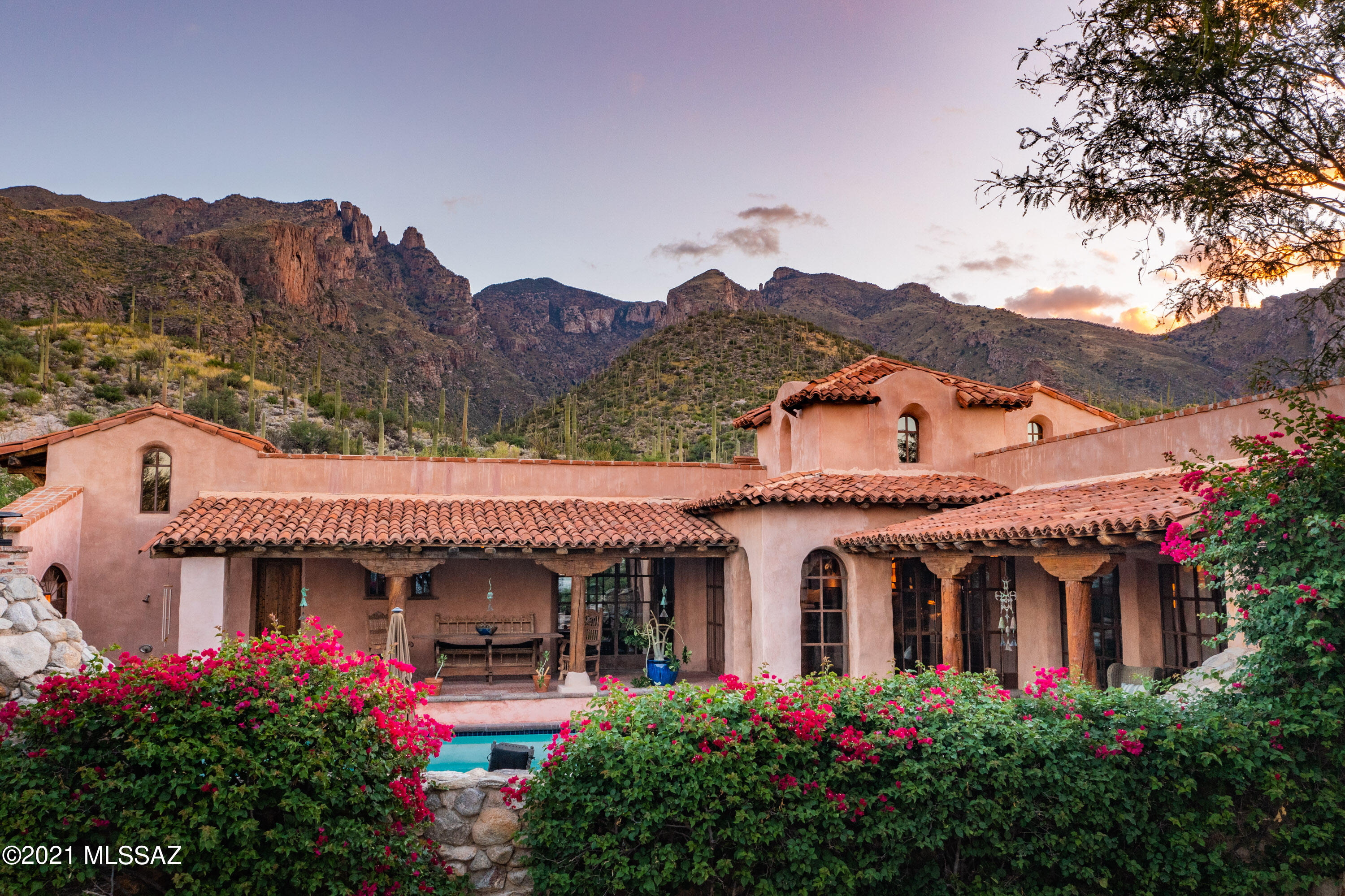 Armed with exquisite taste, a design dream team led by renowned architect Larry Pearson, craftsman from around the world led by Yellowstone Traditions of Bozeman, MT and NO budget, ''Hacienda Rosetta Marie'' was built with only one thing in mind- Quality and Attention to Detail above all else! This impressive home was built after the original owners along with their architect immersed themselves in San Miguel de Allende culture, studying the historic architecture and finding the right artist and craftsman who would later relocate to Tucson to help build this authentic Spanish Colonial Masterpiece.  The end result is nothing short of amazing and is undoubtedly one of the finest homes in Tucson.  ''Hacienda Rosetta Marie'' has been featured in numerous design books and magazines and has received countless design awards since its completion including "Pool of The Year" "Garden of the Year" and "Bathroom of the Century" by Phoenix Home and Garden Magazine! Everything with the exception of the appliances and mechanical systems in the home is handcrafted- reclaimed hardwood floors and antique bricks laid in a herringbone pattern reminiscent of a bygone era add character and warmth-antique beams and timbers give dimension and scale to the rooms- custom windows and doors made by local blacksmiths perfectly frame the view and flood the house with natural light-individually crafted terra cotta roof tiles were made over an old man's knee & no two are alike-the kitchen cabinets and dramatic center island is an intricately hand carved work of art. The interior design was achieved by legendary design team Holler & Saunder who wanted the home to have all the modern conveniences of today yet feel as though it was from the 17th century, and they nailed it!  This exquisite home exudes quality, class and irreplaceable antique materials from around the world you could never duplicate. Built on one of the best view lots in Tucson's most prestigious and coveted community, The Canyons, each room of the home offers unobstructed views of either the towering Catalina Mountains or the twinkling city lights and backs to the Coronado National Forest for total privacy and the ultimate in outdoor Tucson living. Meander through the elaborate lush desert gardens with three outdoor fountains and take in the beauty that was designed by Arnold Rascon which blooms year round to add color to the desert landscape. You will never see another home like this and if unsurpassed quality and attention to detail are what you have been waiting for, this is the one!