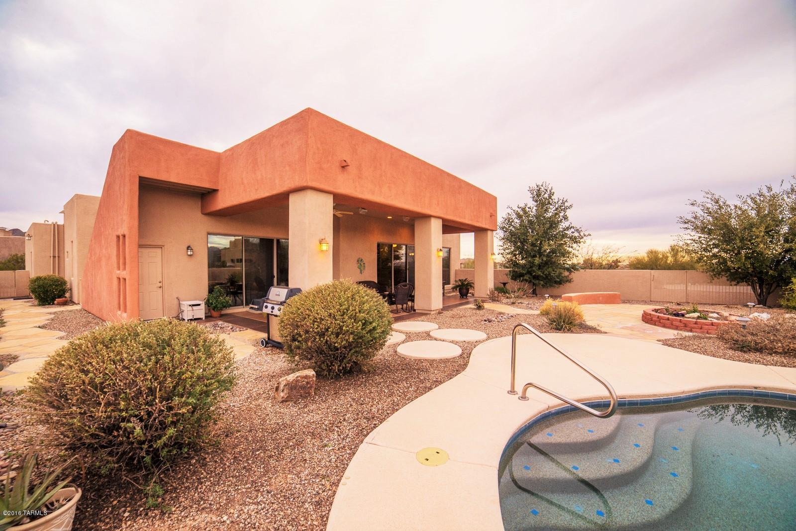 This Semi Custom home offers fantastic views of the mountains and twinkling city lights.  Popular gated community offers privacy, convenience and a comfortable lifestyle.  The three bedroom home features a large kitchen with breakfast bar, high quality rare granite topped island and counters and tons of storage. Huge great room and a split bedroom floor plan, with an amazing master suite with fireplace and separate shower and tub. Master bedroom has sliding doors leading to an expansive covered patio, roof deck, courtyard, pool, and spectacular views from either level.  The separate drive leads to the three car garage tucked out of site.   New H20 heater, $6k custom exterior paint, $30k+ pool, new window treatments. Convenient to I-10 and downtow