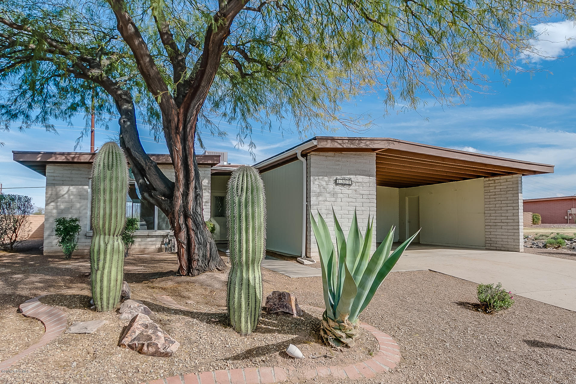 Here it is - a recently updated single-family home on large lot with great mountain views! The classic living room gives you a comfortable place to recline under a radiant skylight with and views through an oversized picture window. The large ceramic tile flooring flows beautifully from the dining area into the kitchen. The kitchen, which is drenched in light from a skylight, offers abundant counter space and cabinetry. Mirrored his and hers closet doors give your master bedroom additional spaciousness while reflecting inspiring mountain views through your patio doors. Your updated master bath has beautiful vanity tops with modern plumbing fixtures, contemporary mirrors and light fixtures, and a jetted tub to relax. You'll love the extended living area with a cool breezeway  screen enclosure where you can enjoy fresh air all year round. The oversized backyard will warm your heart with its mature swaying palm trees, assorted desert vegetation and trickling waterfall with a blue water pond. All of these features, plus terrific views of the Santa Rita Mountains!