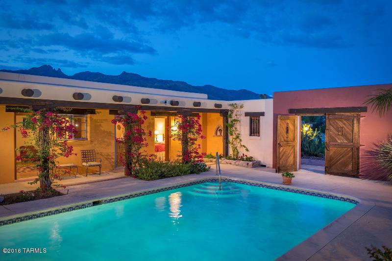 This amazing home is set high on a hill providing privacy and views. The long driveway leads to a lush front patio and a massive Mexican Hacienda gate with hand forged hinges which opens to the center courtyard with pool and expansive sitting area. This home has an Arizona Inn feel due to the authentic Old World charm and elegance. Wonderful Vegas, Pecky Cypress Planked Ceilings, custom Mexican tile, warm, Saltillo tile and extensive niches. Beautifully remodeled kitchen with granite counters. The guest quarters have a bedroom with bath, separate sitting area with fireplace, sink, fridge and a private entrance which opens to the center courtyard/pool. Beautifully cared for and maintained.