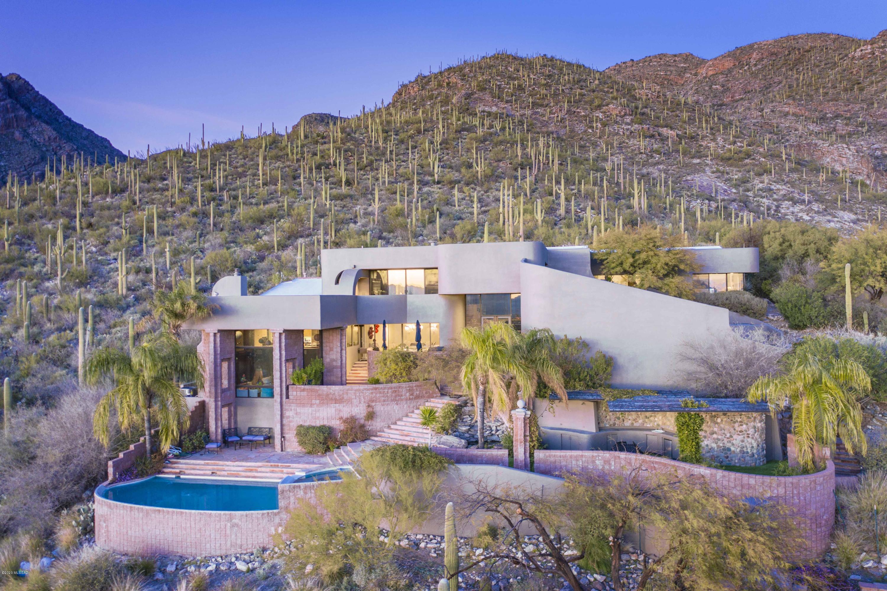 Top of the world views on 4 acres bordering the National Forest. Stunning pure contemporary w/city, mountain & sunset views in gated Sin Vacas. Exquisite living room w/dramatic 20 ft.high ceilings, incredible walls of windows, fireplace, beautiful wood floors, formal dining room, gourmet island kitchen with granite countertops , stainless steel appliances,  gas stove top,  double ovens, refrigerator, wine cooler. breakfast bar for 10, family room. marble tile floors, 4 BR's + exercise/computer room, 4 BA's including master suite 
w/luxurious bath featuring granite & marble, amazing shower, lg walk in closet & priv balcony to capture the views. Enjoy  resort like bkyd w/pool, spa, cov'd patios, grass, BBQ, 3, car garage, circular driveway & views, views!!Flr  plan under photos/virtual tou