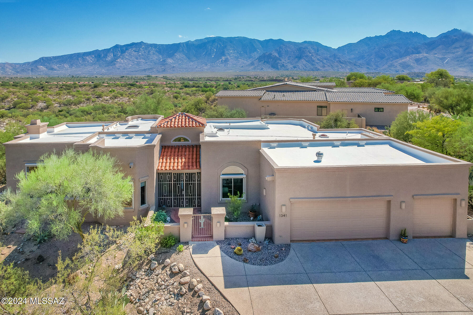 Spectacular, custom 3BD/3BA +Den (2,813 sq ft) luxury home sits high in desirable High Mesa Estates with East facing Catalina views. Extended driveway flows to a charming, gated courtyard with brick pavers and decorative wrought iron porch enclosure. This idyllic home is set back on almost an acre offering 3 en suite bedrooms, an expanded, open concept living & dining room with wood plank & beam ceiling, large view windows, media wall/surround sound, fireplace with Travertine surround plus Travertine covered wet bar for entertaining. Den has been converted into an office featuring glass panel French doors and built-in workstations on three walls. Striking gourmet kitchen hosts Travertine countertops, stainless appliances (double ovens/microwave/gas cooktop on center island), walk-in pantry, plus dining nook with views. Elegant Owner's suite with French door entry and recessed ceiling hosts a spa-like bath with dual sink vanity, corner soaking tub, tiled walk-in shower, makeup station and dual closets. Other thoughtful amenities include 3 bay windows, 6 skylights, 2 indoor/outdoor fireplaces, central vacuum, water softener, security alarm, European Oak plank floors in guest rooms, 5 patio entrances and 5 rain barrels. Three car garage with enclosed multi-use third bay has large storage room with shelving. Rolling sunscreens cover most windows. Retreat to a rear oasis offering a covered patio with pavers, BBQ station with fridge, heated saltwater pool and raised spa with trickling waterfall, mature desert landscaping plus Catalina views. A desert retreat perfect for the most discerning buyer!
