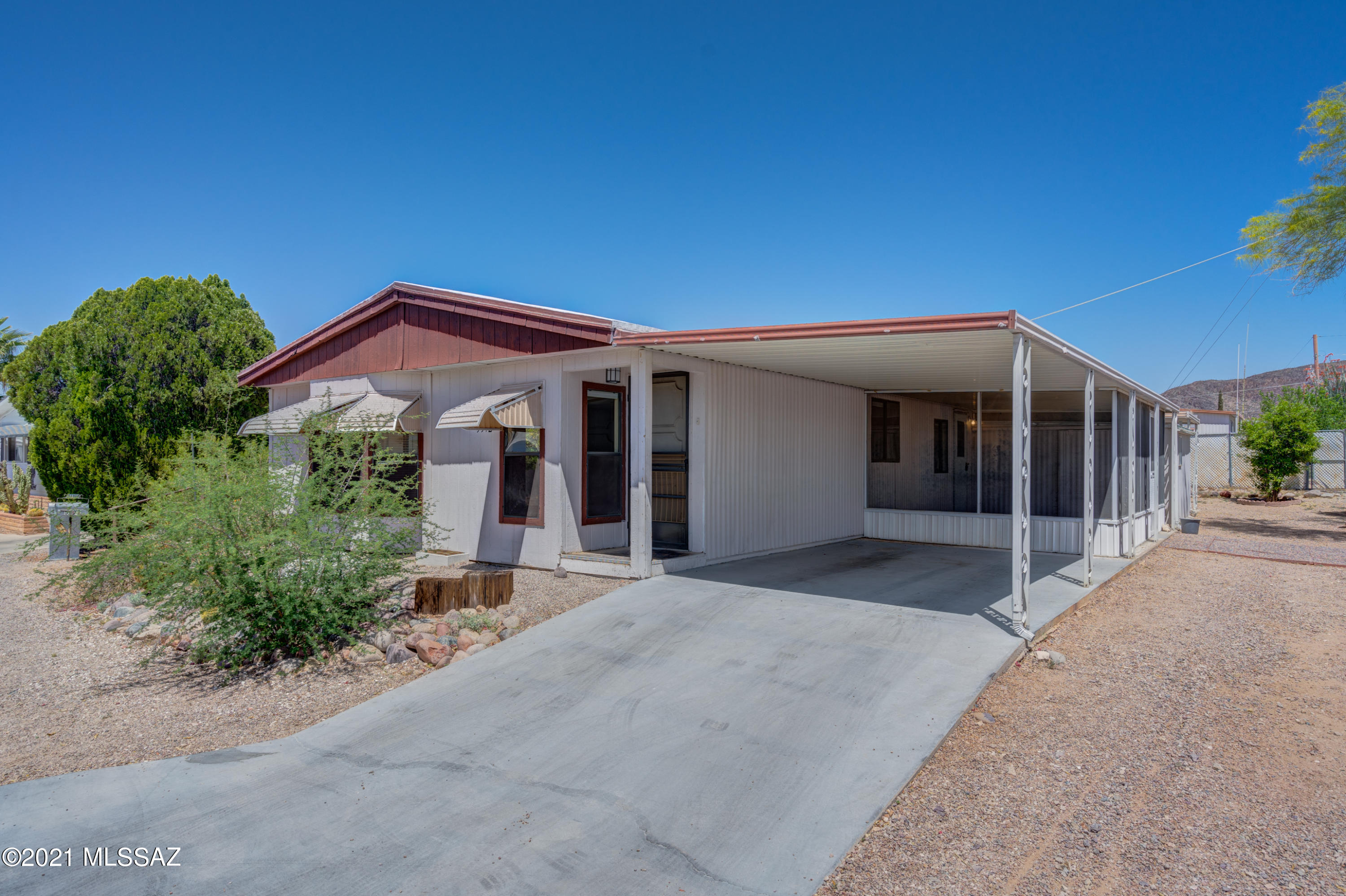 Bright and open 2BD, 2 BA double wide home within Tucson Estates 55+ community. Kitchen features a breakfast bar open to spacious dining and living areas. Large laundry room with built in desk and extra cabinets for storage. Large master bedroom with en-suite and walk-in closet. Large Arizona room to enjoy the great Tucson weather. Attached single car port, storage & patio for golf cart parking. New gas lines and meter have been installed. Come look at all the amenities Tucson Estates HOA has to offer; free 18 hole golf course, tennis, pickle ball, exercise facility, 3 pools, sauna, hot tub, shuffleboard, library, trash pickup, free weekly bus trips. All this surrounded by beautiful mountain views! And, you own the land! 15 minutes from downtown Tucson and many popular venues.