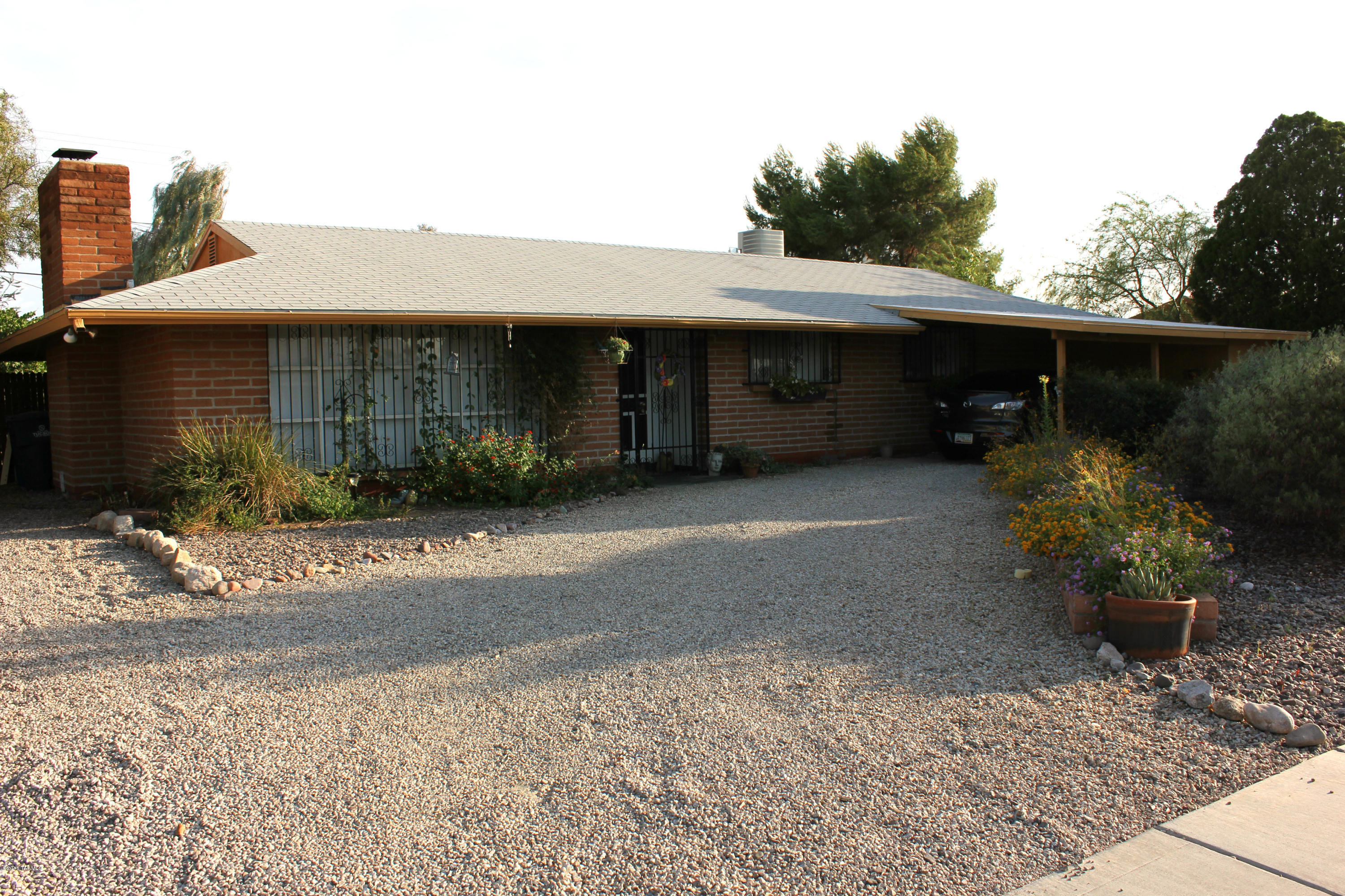 Affordable and move-in ready on the east side!  Unique and wonderful red-adobe-brick home in great location convenient to everything! Pride-of-ownership abounds in this well-maintained and updated home that has only had two owners. Custom paint and attention to detail adds to the welcoming feel. See all of the little details and special features that will make this your perfect home! Tile floors throughout, large bedrooms, modern, updated and newer appliances. Air conditioning unit less that a year old. 
Mature landscaping, plenty of storage, large screened-in porch, workshop with wrap around storage shelving, custom chicken coop, and great Ramada area makes it feel like your own little paradise. This home has it all!