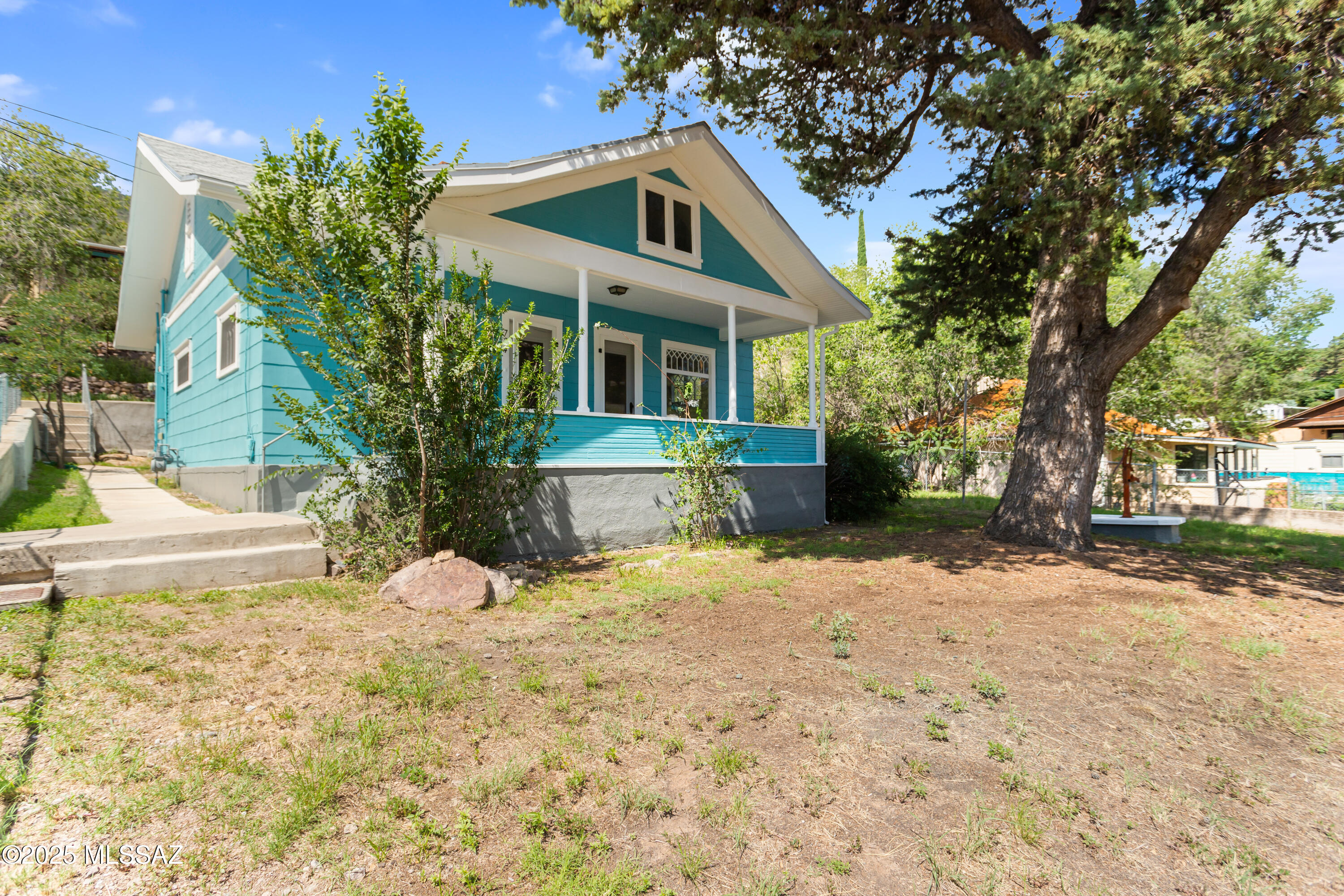 Charming 1916 Craftsman Bungalow on a Spacious Corner Lot
Step into timeless charm with this beautifully maintained 1916 Craftsman-style bungalow, nestled on an expansive 8,000 sq. ft. corner lot. The fully fenced yard features mature pine trees, offering privacy and a serene, shaded retreat.
Relax on the wide front porch and enjoy fabulous views—perfect for sipping your morning coffee or watching the world go by. East-to-west windows fill the home with natural light and gentle breezes, creating a bright, airy atmosphere throughout.
Lovingly preserved with original period details, this home has been thoughtfully updated for modern comfort, including a new roof, central HVAC with insulated ceilings, and 200 Amp service. The restored full-size garage features an electric opener and ample driveway parking.
Inside, discover a cozy floor plan with approximately 866 sq. ft. of living space:
*	Living Room & Dining Room: Warm wood floors and ceiling fans in every room.
*	Eat-in Kitchen: Ample pantry space and convenient access to back screened porch.
*	Bathroom: Newly remodeled with a double-sink vanity, claw-foot tub, and plenty of storage.
*	Office/Den: With private outdoor access, ideal for work or hobbies.
Additional features include washer/dryer hookups, abundant storage, and a single-floor layout that maximizes comfort and ease of living.
Prime Location: Just a 5-minute drive (or 24-minute walk) to the Bisbee Mining Museum, Brewery Gulch, shops, and restaurants. Only a 3-minute drive (15-minute walk) to the Iron Man statue, local eateries, and the historic St. Patrick's Church and Cochise County Courthouse.

Key Highlights:
*	1 Bedroom | 1 Full Bath | Approx. 866 sq. ft.
*	New Central Heating & AC
*	Wide Front Porch with Fabulous Views
*	Driveway & Restored Garage
*	Large, Shaded Fenced Yard
*	Wood Floors & Ceiling Fans Throughout
*	Eat-in Kitchen & Pantry
*	Office/Den with Outdoor Access
Welcome Home: This charming Craftsman bungalow perfectly blends original character with modern updates. Comfortable, inviting, and full of personality, this home is truly a must-see!