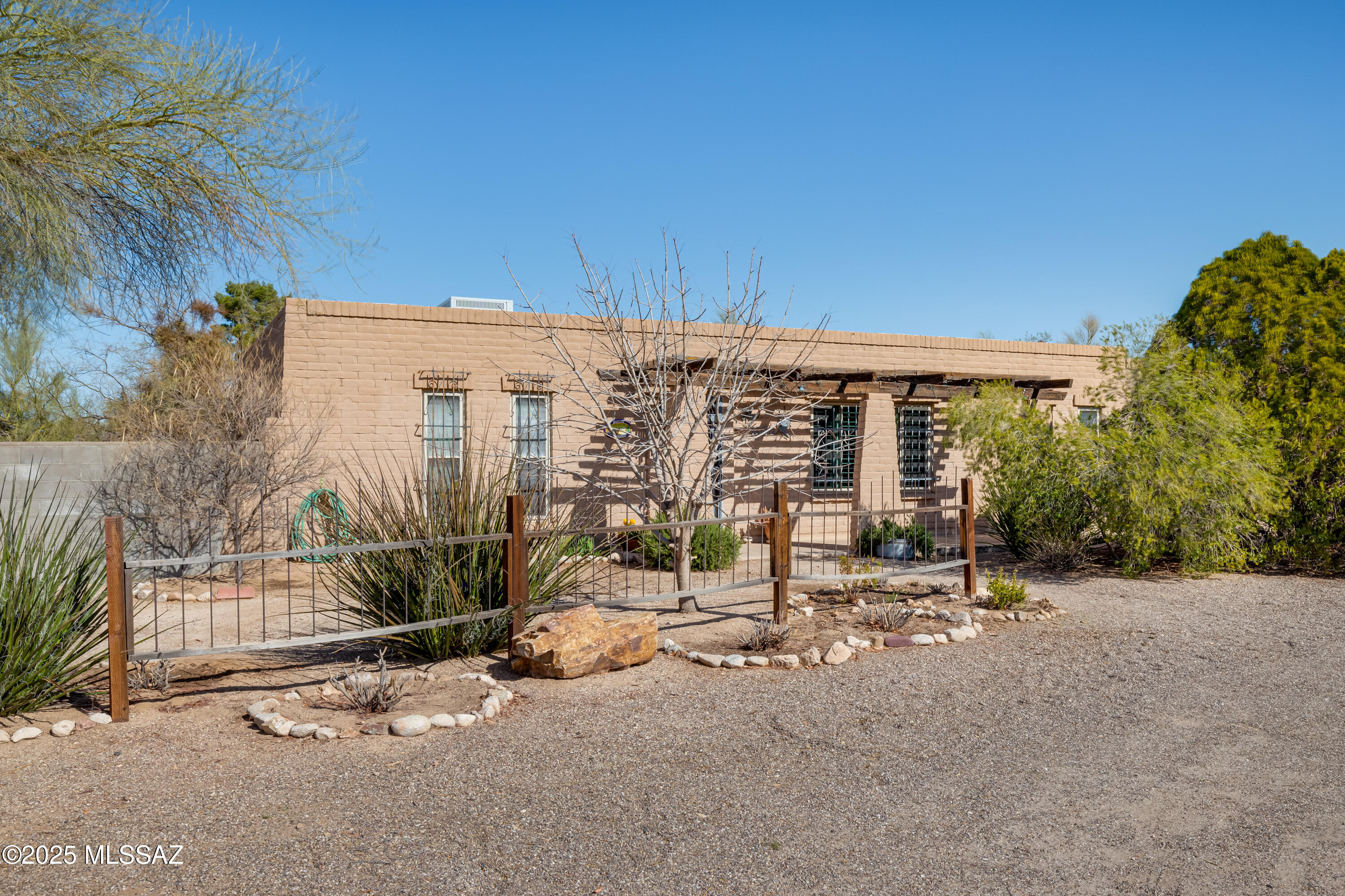 Charming 3-bed, 2-bath home on **.37 acres** with No HOA! Spacious living areas feature saltillo tile, exposed brick and skylights for natural light. The kitchen offers bold cabinetry and a breakfast bar. Owner's suite includes mirrored closets and a walk-in shower. Two versatile guest rooms, perfect for crafts or an office. **New HVAC and water heater (2023) for peace of mind.** Fully enclosed, double gated, backyard, with mature trees and room for pool, playground, and more. **Large garage with ample storage and a dedicated workshop.** Serene desert living just minutes from town—don't miss this unique opportunity!